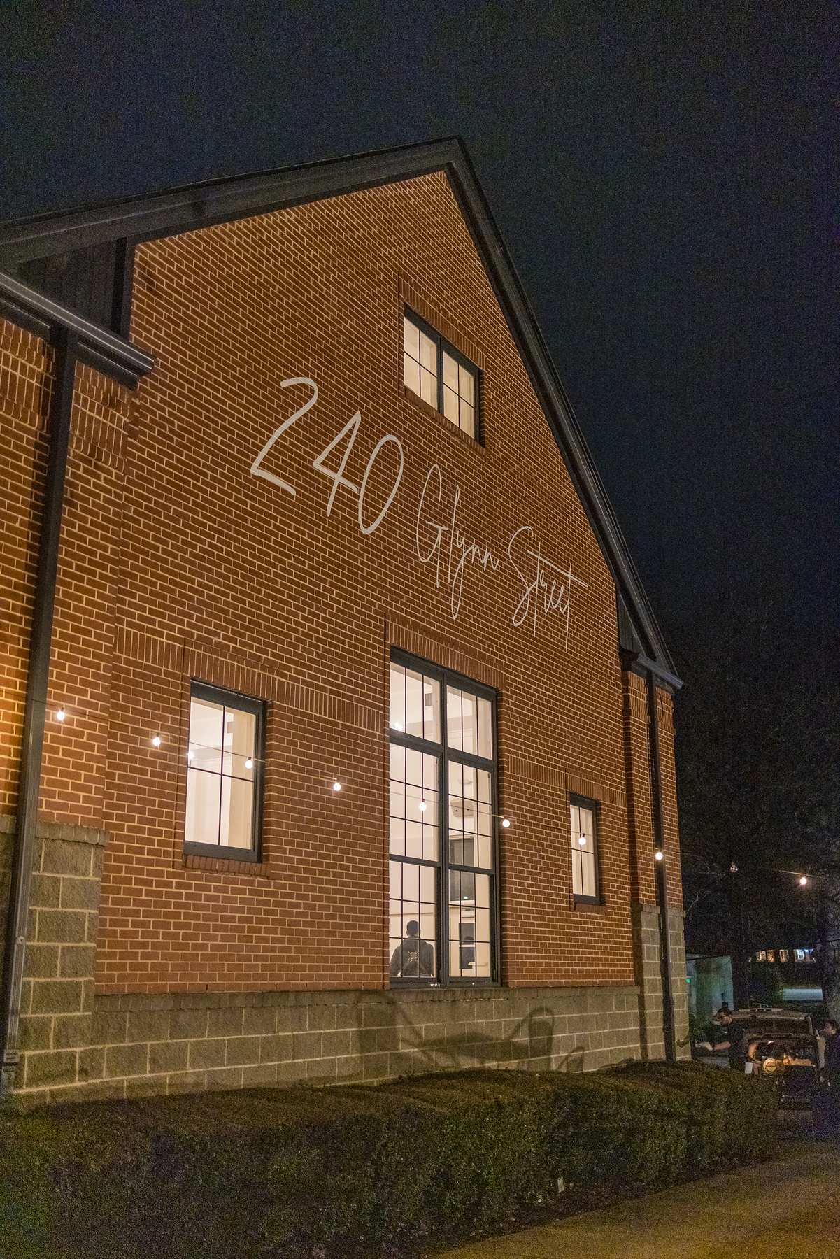 240 Glynn Street sign on the brick building at night in Fayetteville