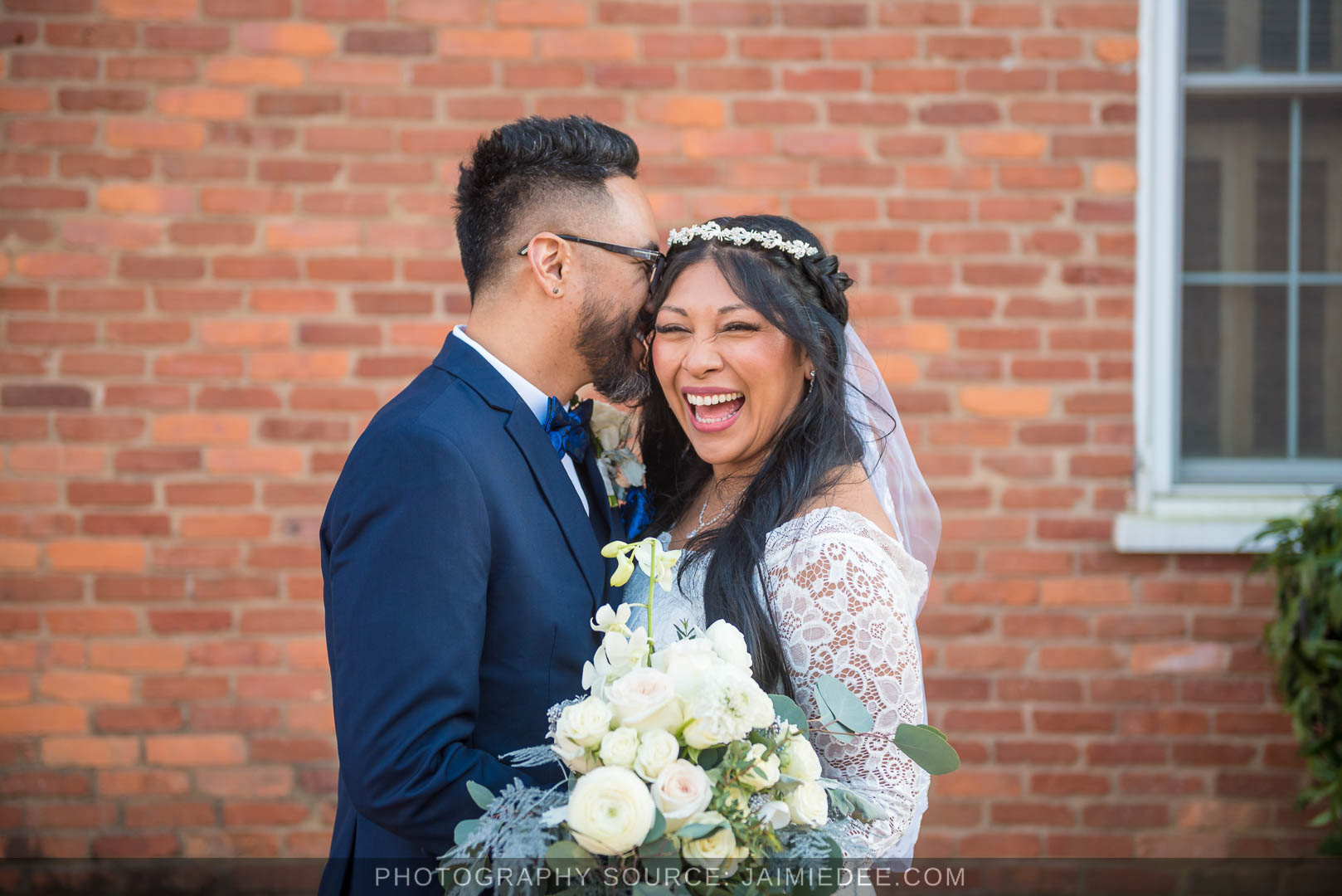 Couple kissing against a brick wall near the Marietta courthouse square after their wedding