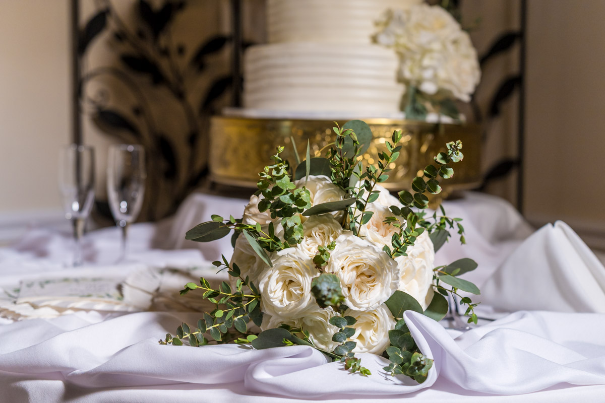 wedding bouquet sitting next to wedding cake - florals from Flowers From Us Florist Alpharetta