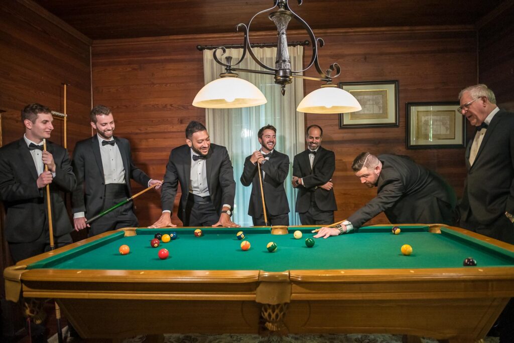 Groom and groomsmen playing pool inside the Wheeler House
