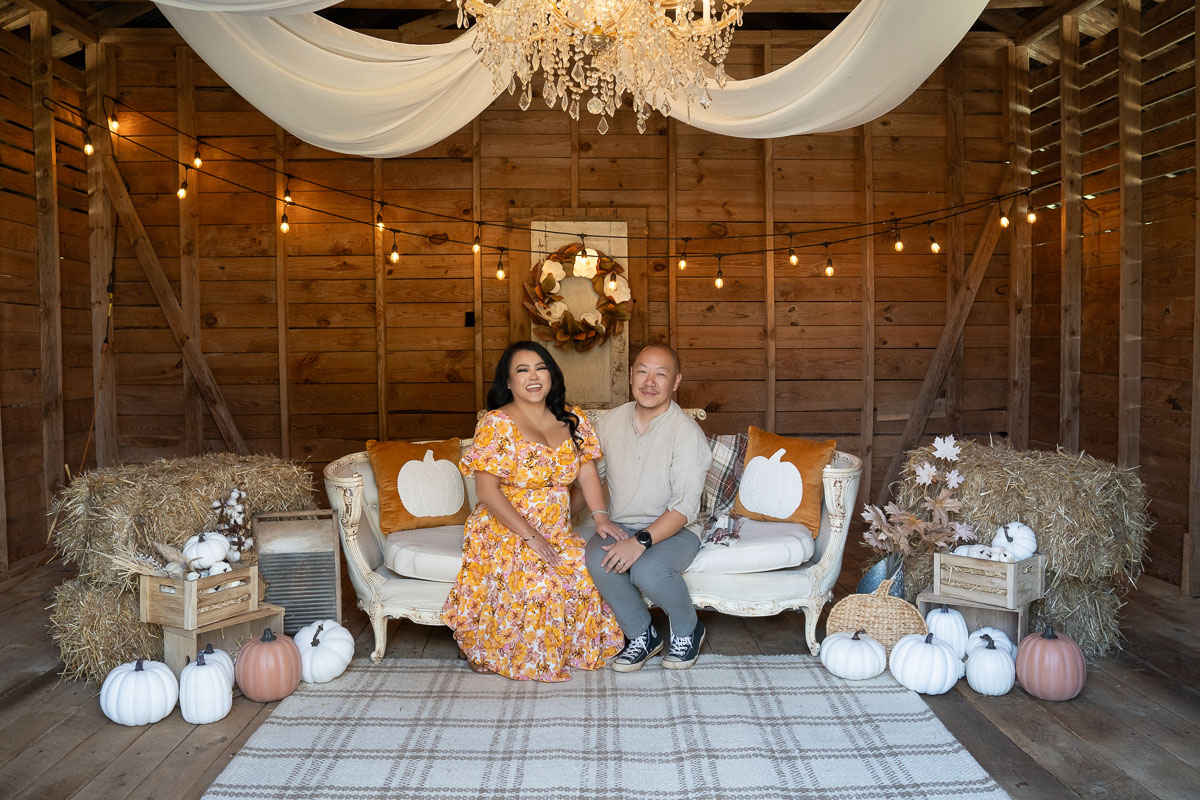 Couple seated on the white settee in the White Pumpkin Barn at Prospect Farms