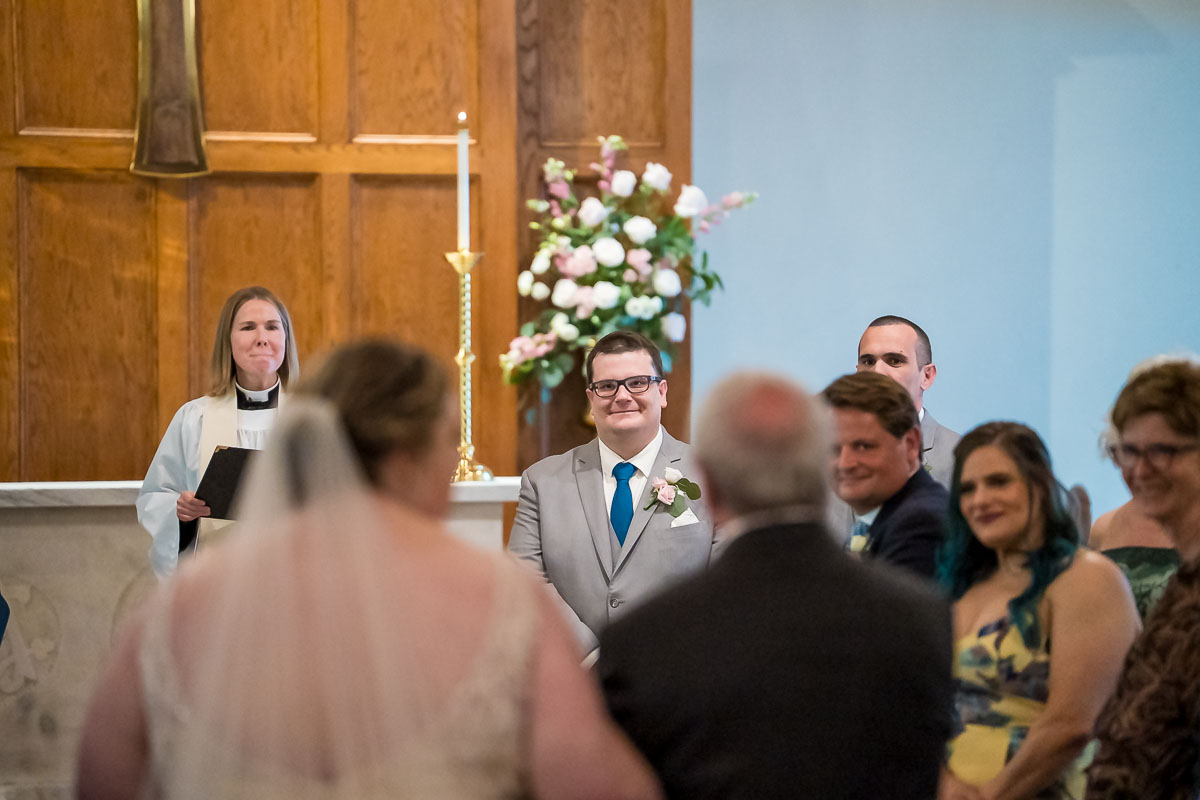 Bride walking down the aisle towards the groom during wedding ceremony at The Episcopal Church of the Epiphany