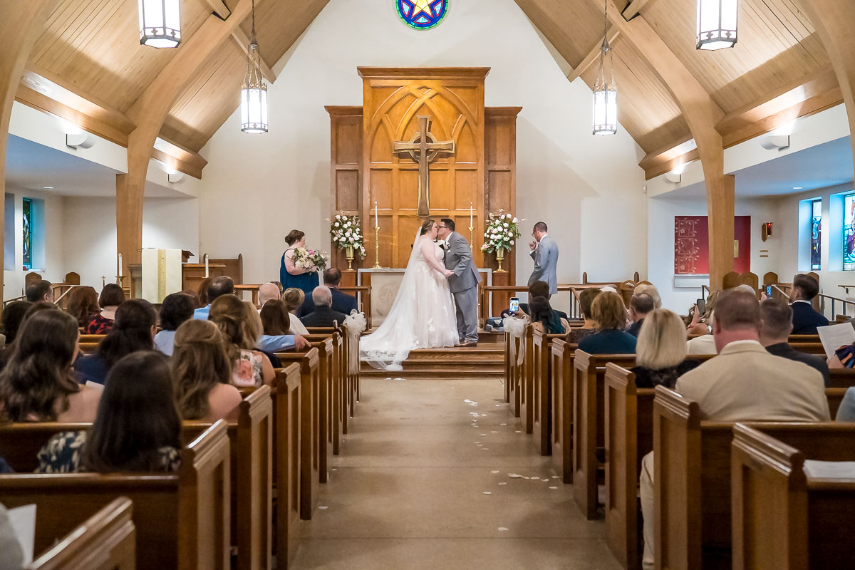 Bride and Groom first kiss during wedding ceremony at The Episcopal Church of the Epiphany