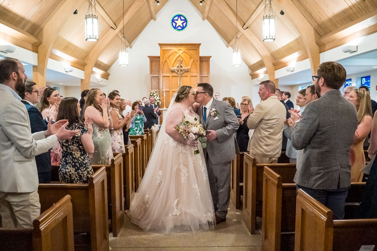 Bride and Groom walking down the aisle after first kiss during wedding ceremony at The Episcopal Church of the Epiphany