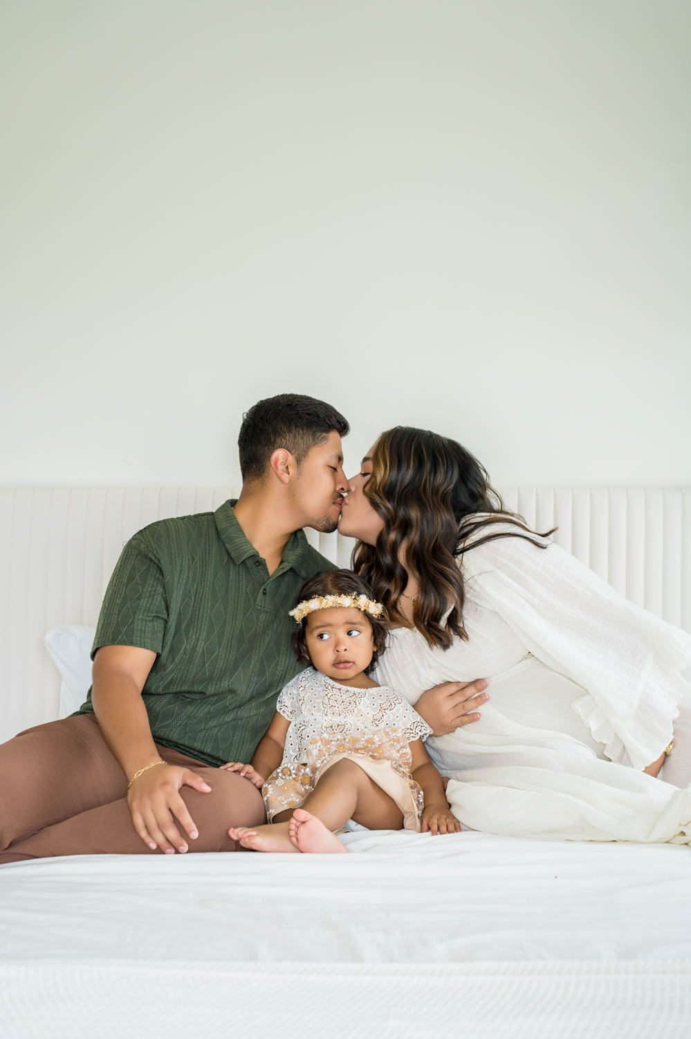 Young family portrait on the bed in the Nest Room in the Farmhouse at Prospect Farms