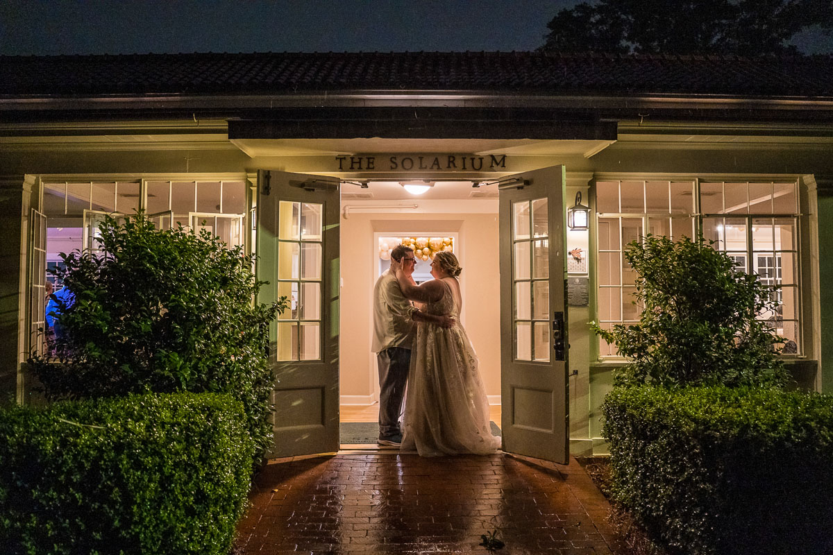 A night time reception photo of the couple in front of the Solarium at Historic Scottish Rite wedding venue in Decatur