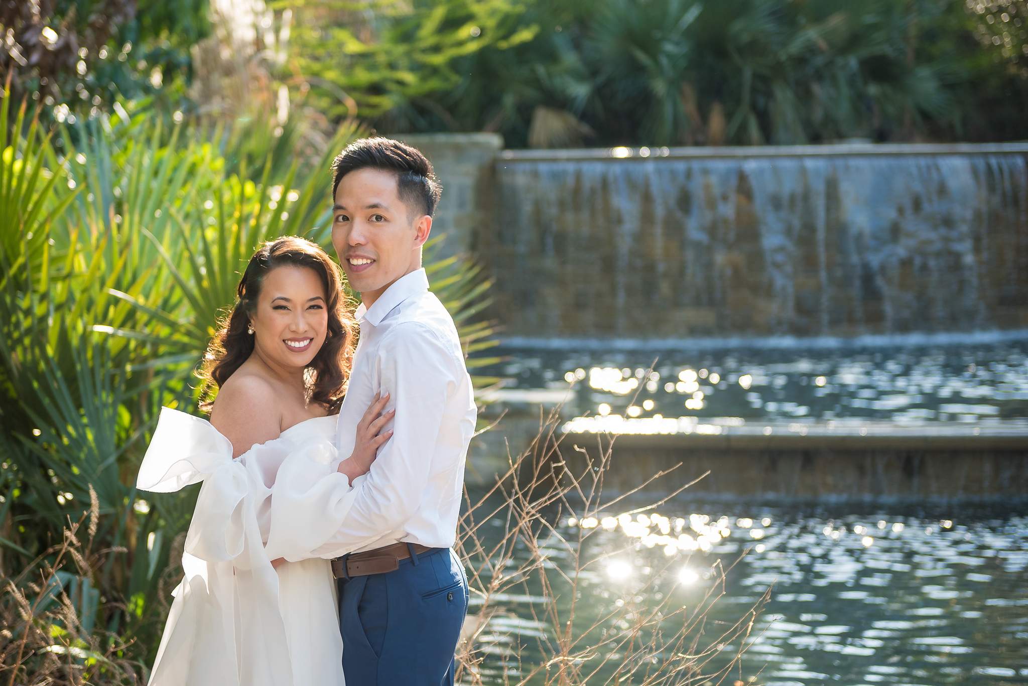 Couple cheek to cheek in front of glittering water at the Atlanta Botanical Garden
