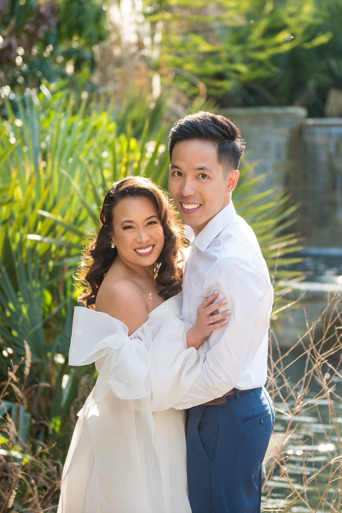 Vertical portrait of a smiling couple by the cascade pool at the Atlanta Botanical Garden