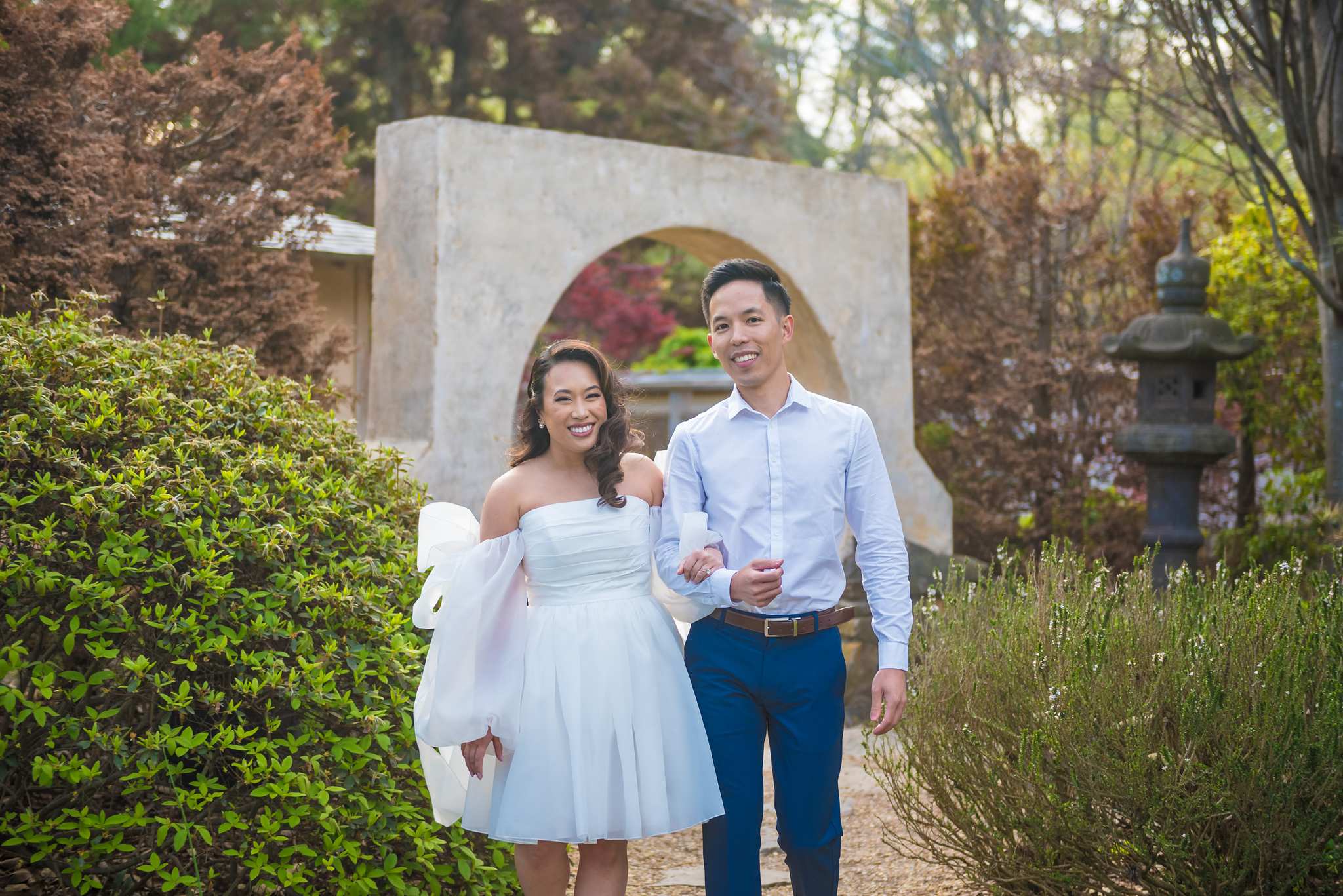 Smiling couple in front of the round moon gate in the Japanese Garden