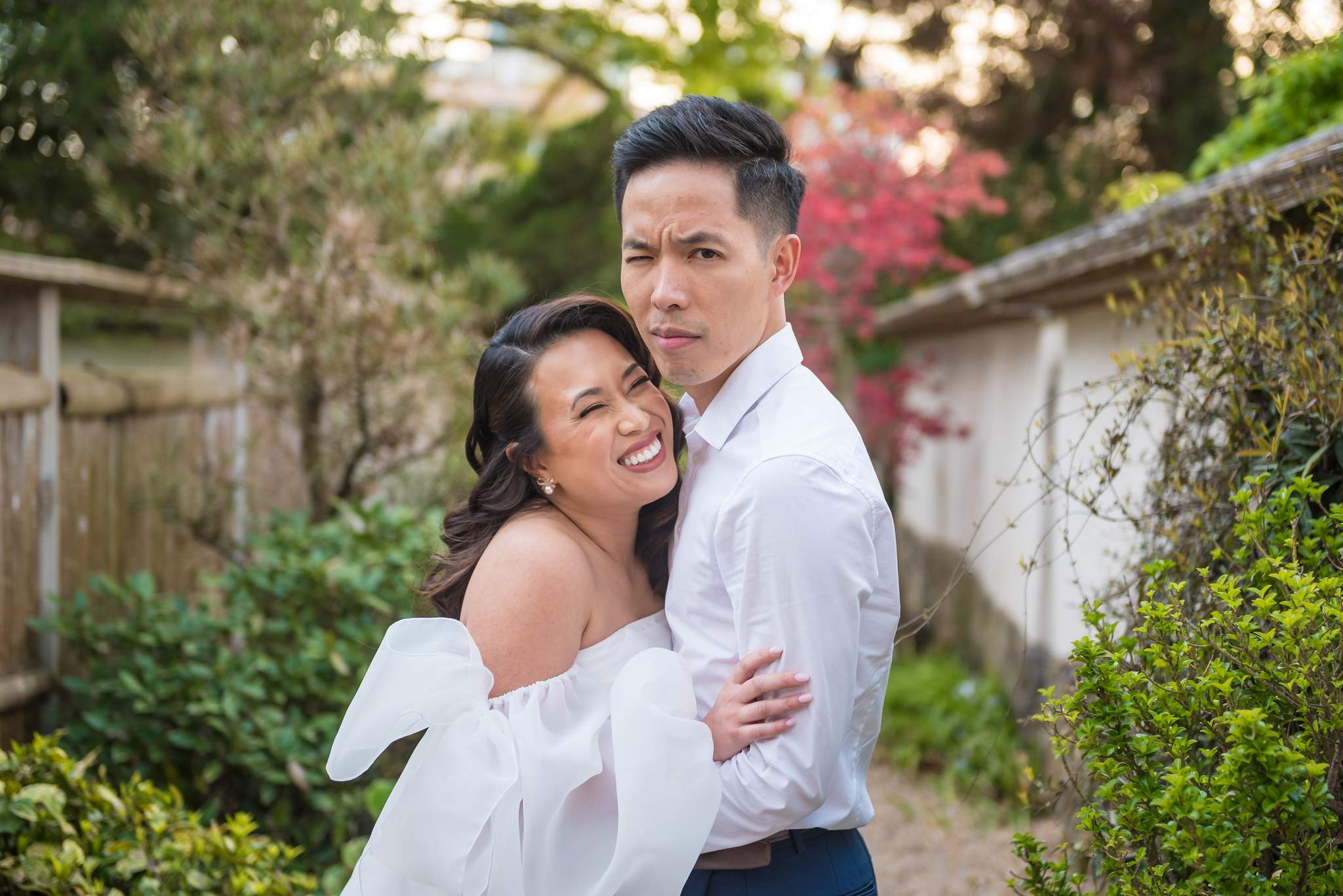 Close portrait of a smiling couple in the Japanese Garden with red maple leaves