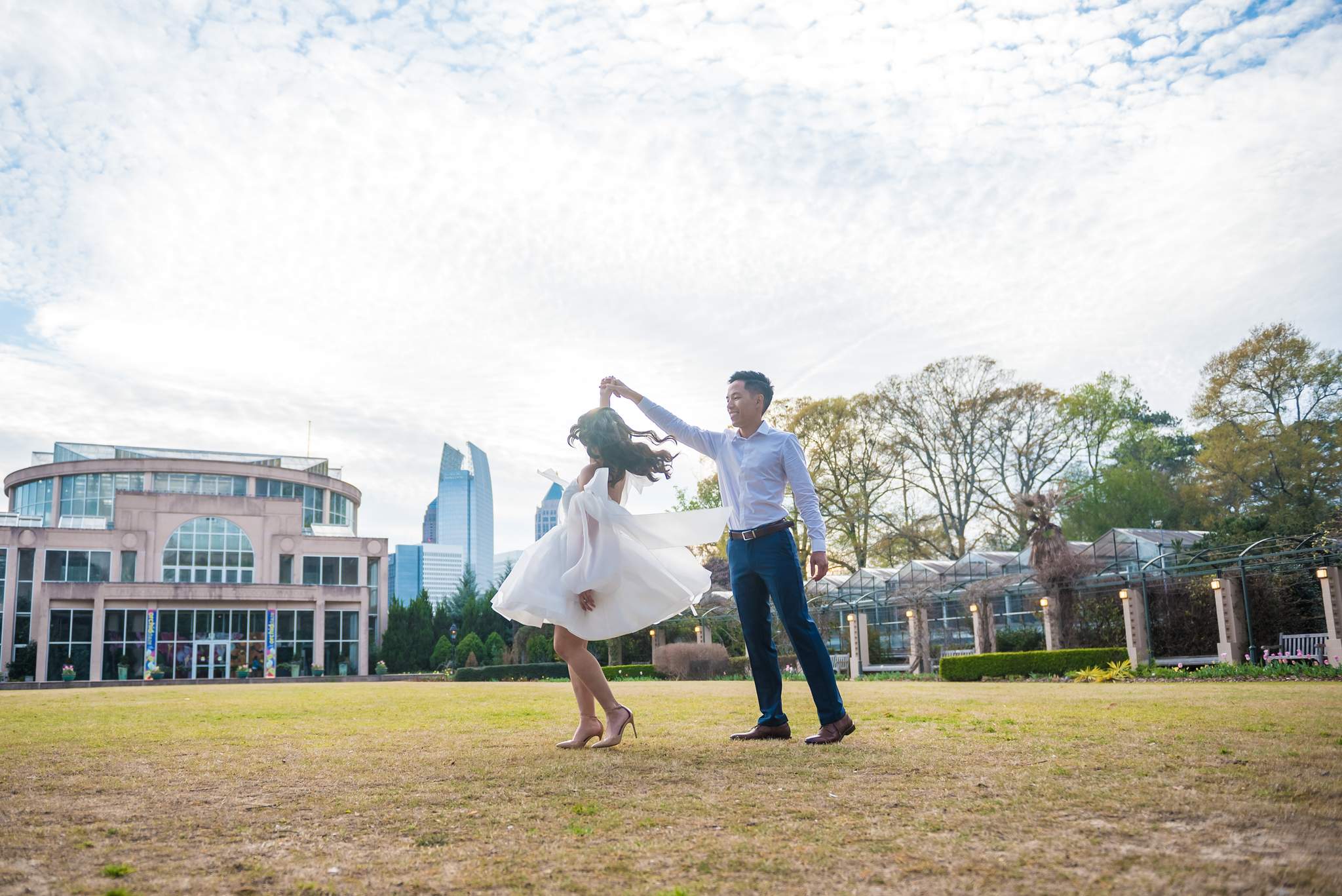 Couple dancing on the Great Lawn with the Midtown Atlanta skyline behind them