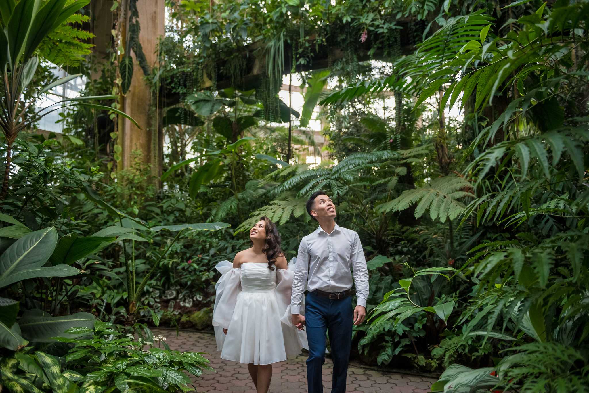 Couple walking through lush tropical plants in the Fuqua Conservatory