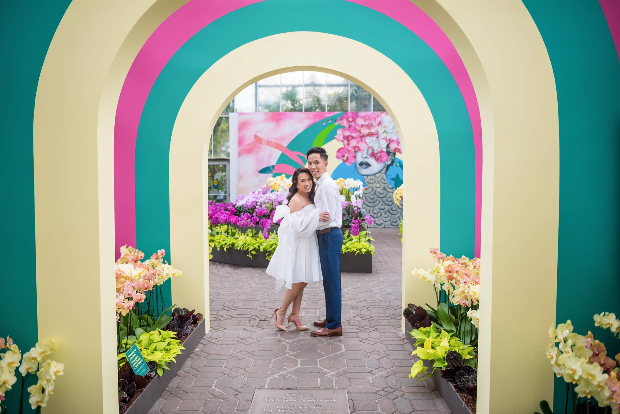 Couple framed by colorful painted arches during the seasonal orchid display