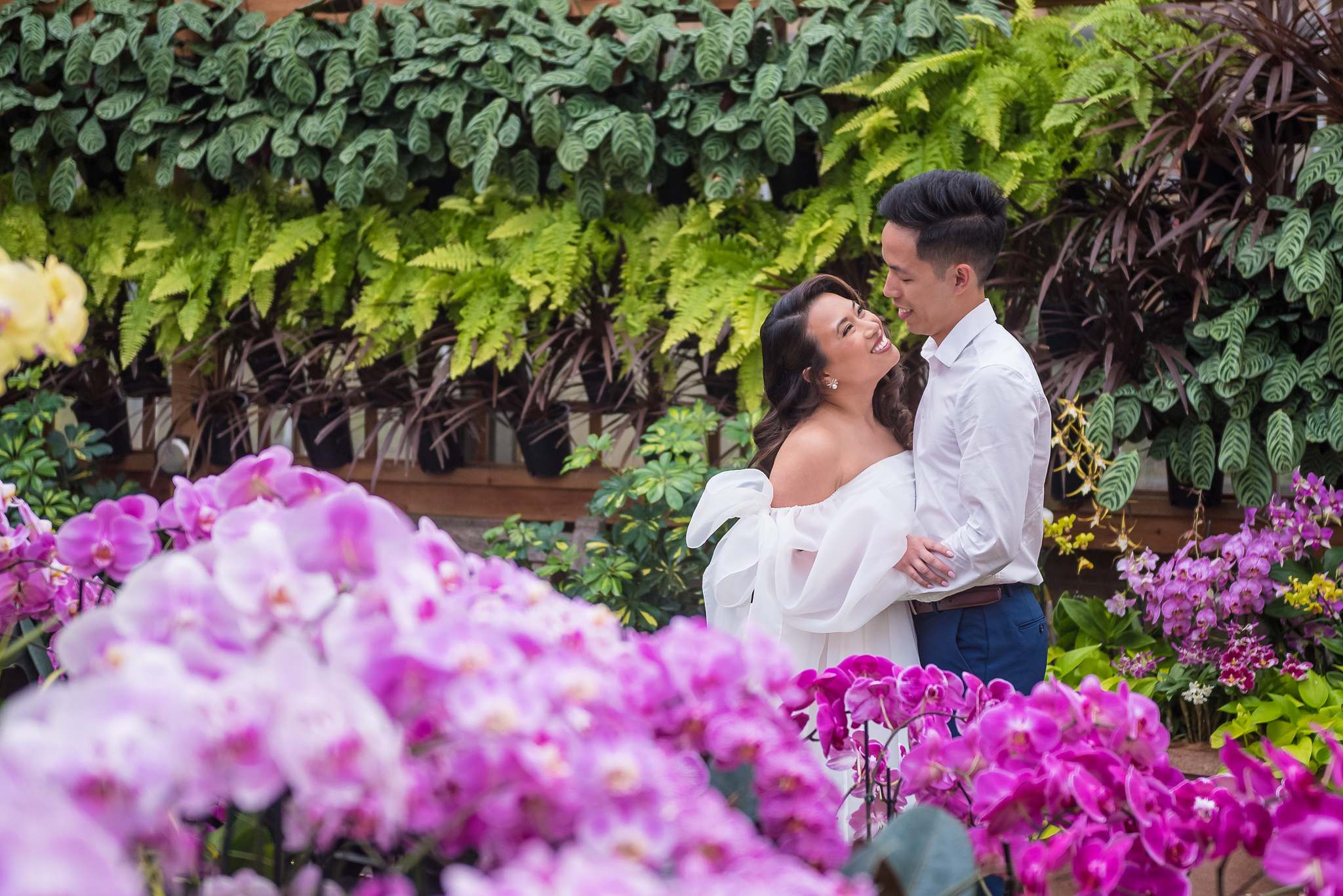 Couple laughing together among purple orchids in the Fuqua Orchid Center