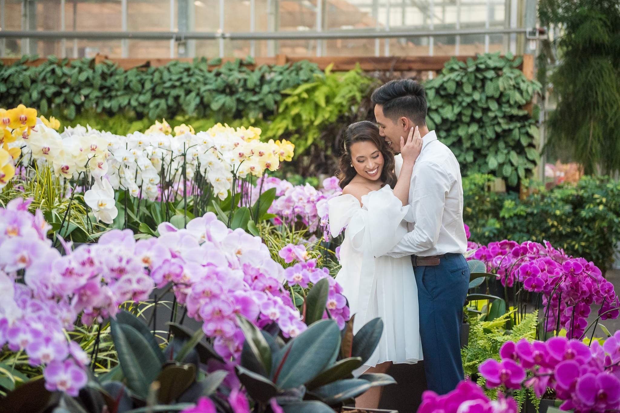 Couple embracing beside white and purple orchids in the orchid display