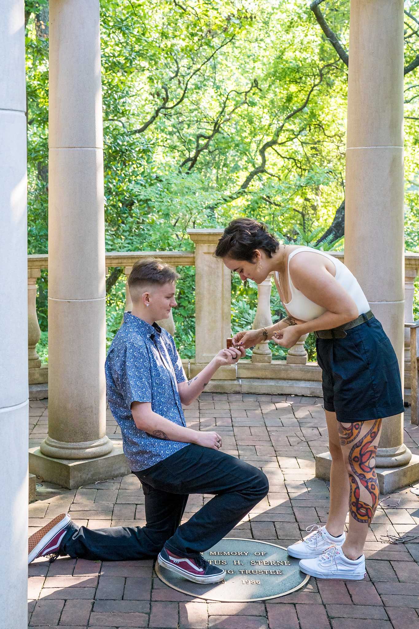 Leaning down to look at the ring during a surprise proposal at the Atlanta Botanical Garden