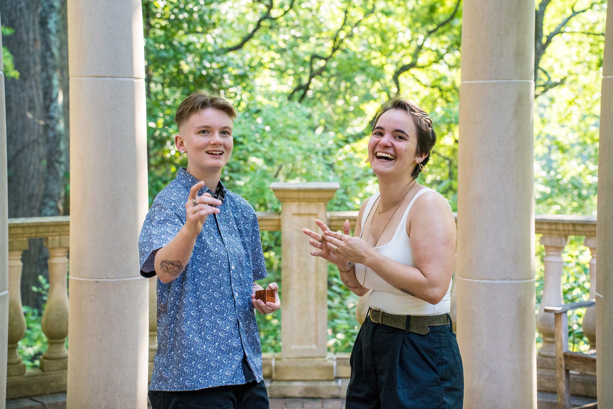 Laughing together and showing off the engagement ring in the garden gazebo