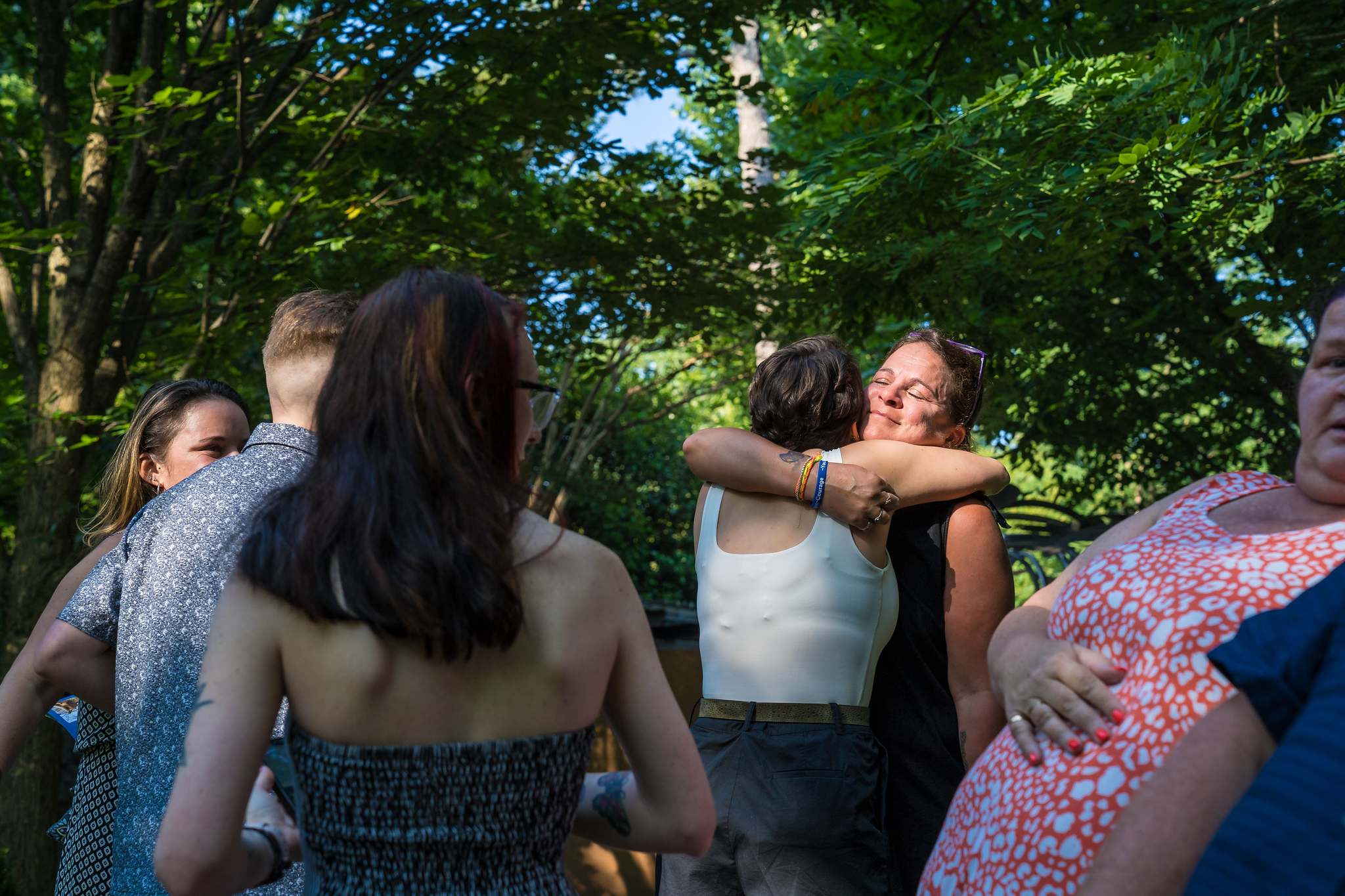 Friends and family rush in with hugs right after a proposal at the Atlanta Botanical Garden