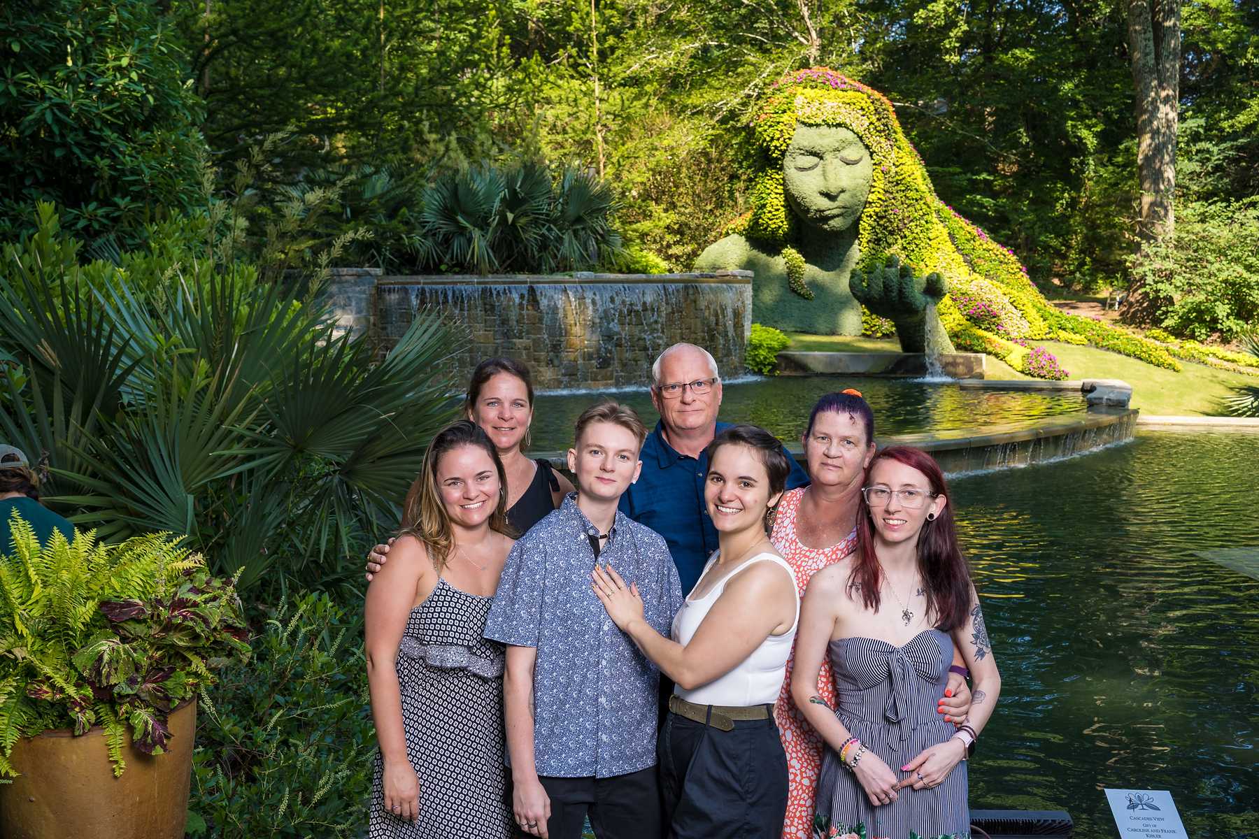 Family group photo in front of the Earth Goddess sculpture after a garden proposal