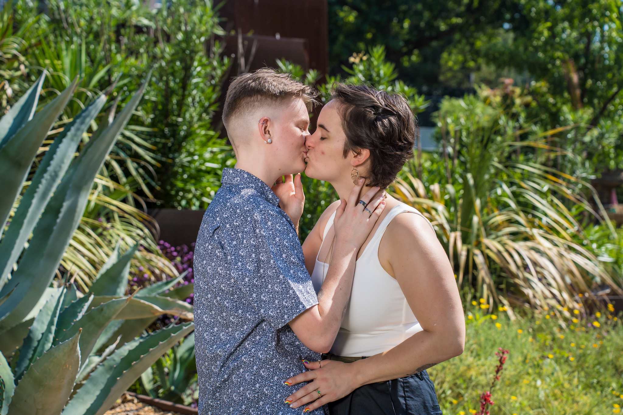 Engaged couple sharing a kiss among agave and desert plants at the Atlanta Botanical Garden