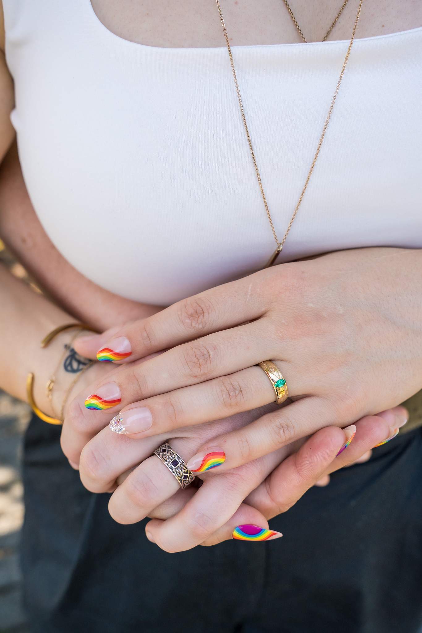 Close-up of hands and engagement ring with colorful nails
