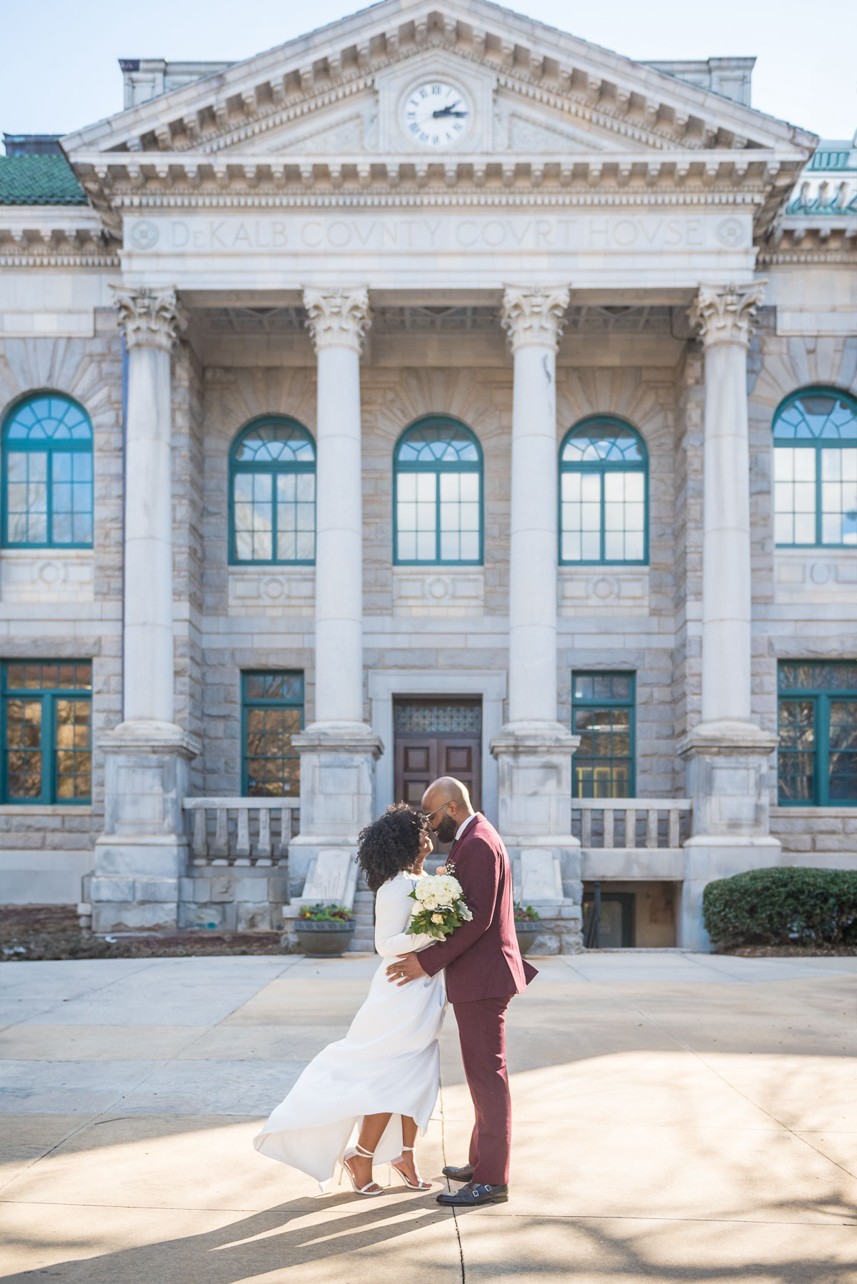 Couple outside a columned historic courthouse after their courthouse wedding in Georgia