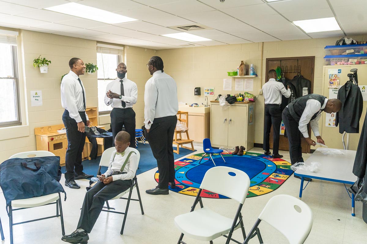 Groom and groomsmen getting ready in classroom at St. Ann's Catholic Church in Marietta on wedding day