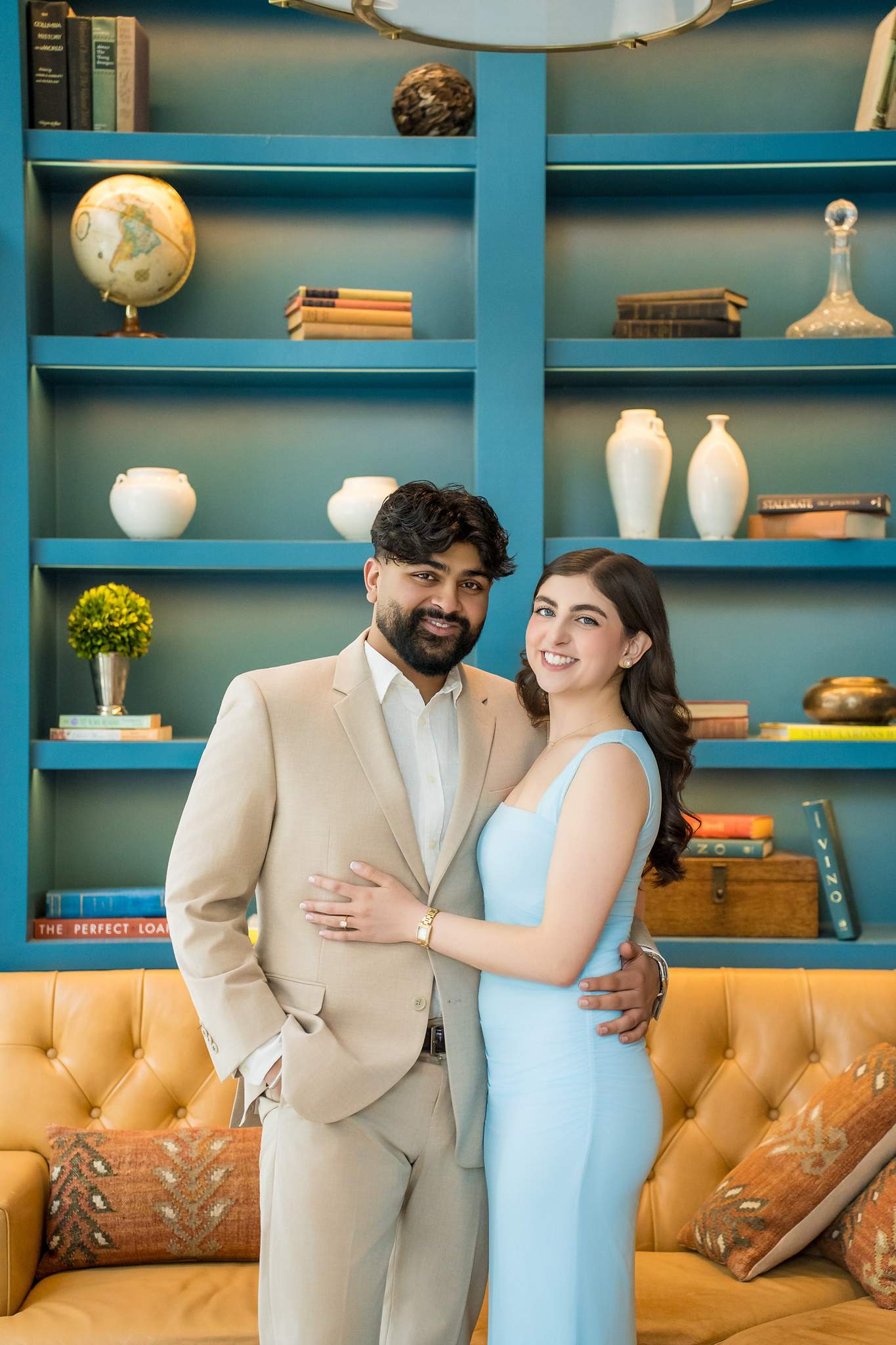 Couple embracing in front of teal library shelves at Chateau Elan
