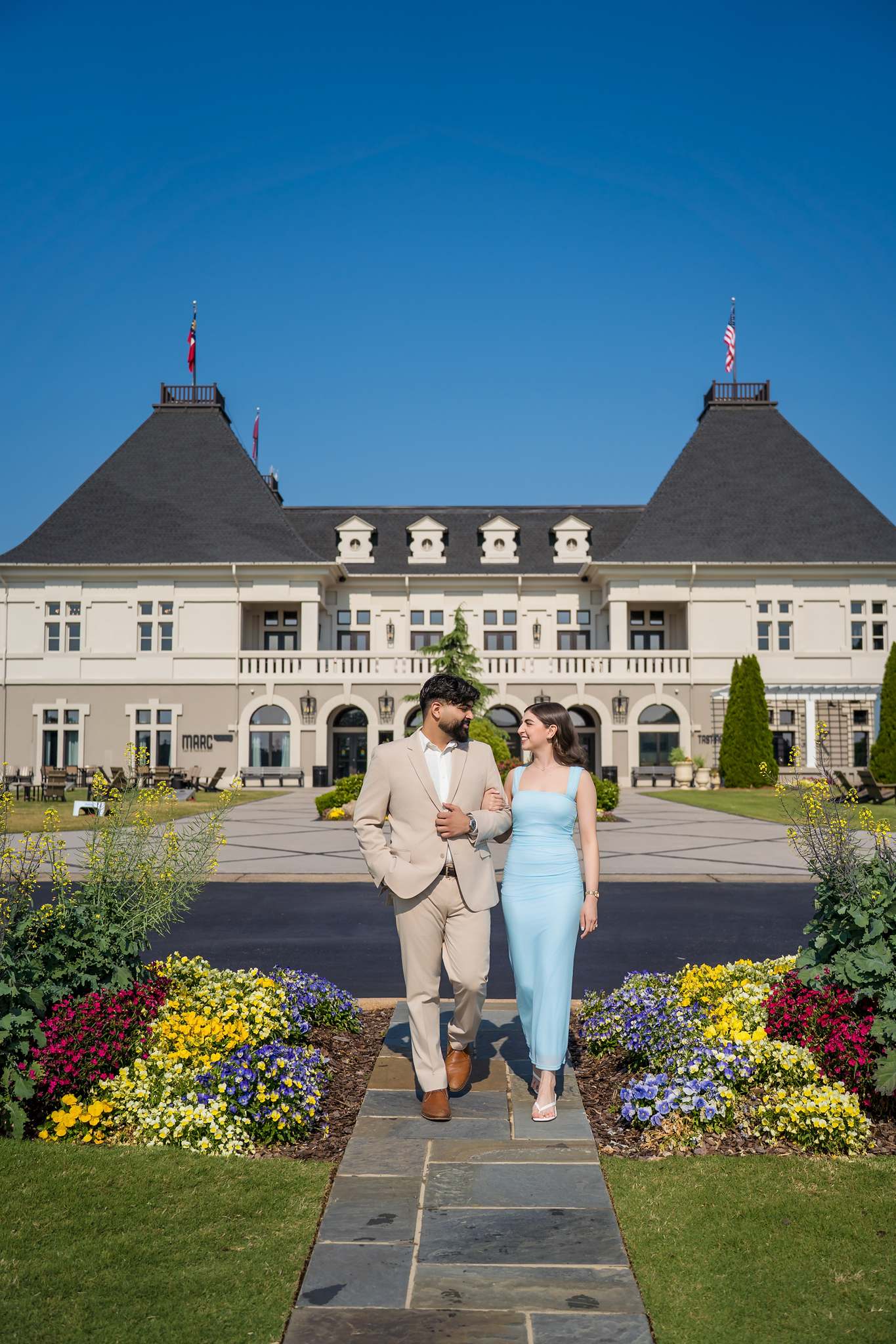 Couple walking the garden path toward the front of the Chateau Elan chateau