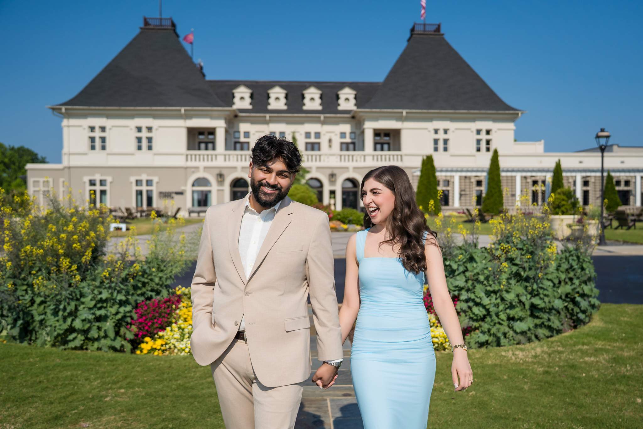 Wide view of the engaged couple in front of the Chateau Elan chateau and gardens