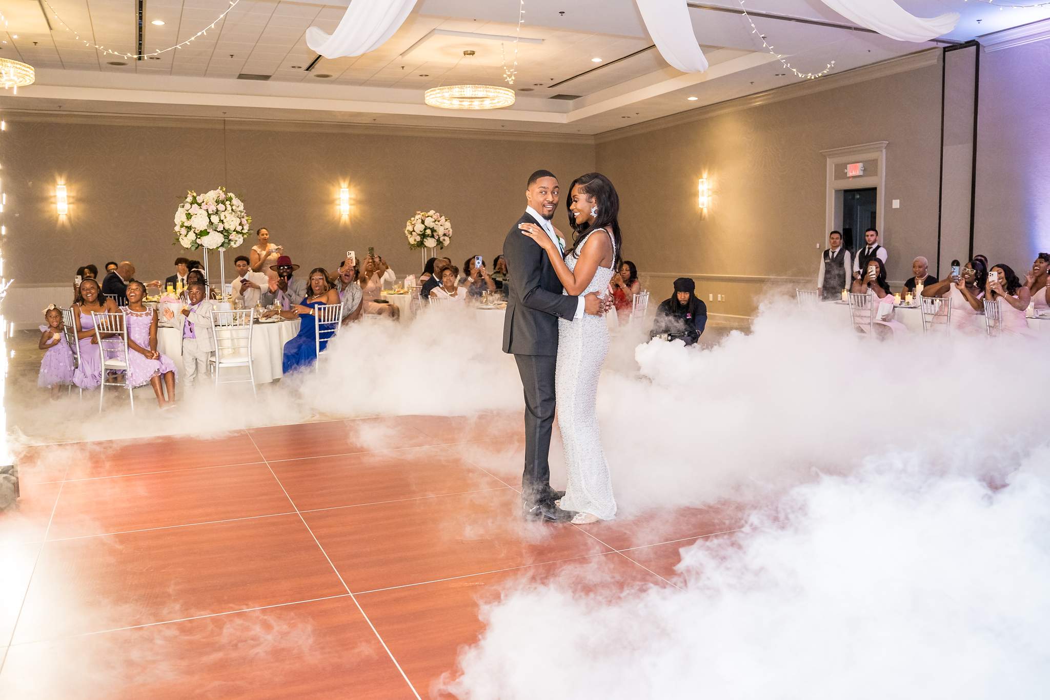 Bride and groom share their first dance on a cloud of low fog in the Chateau Elan ballroom