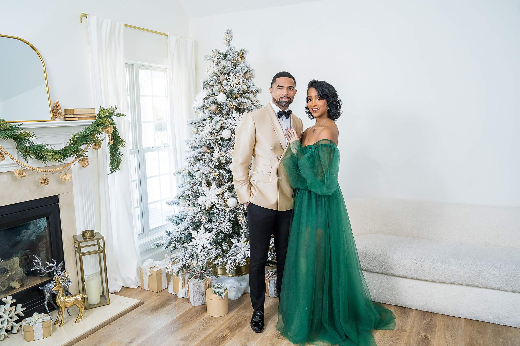Mother in an emerald tulle gown, father in a champagne tuxedo jacket and son in green velvet by the Christmas tree