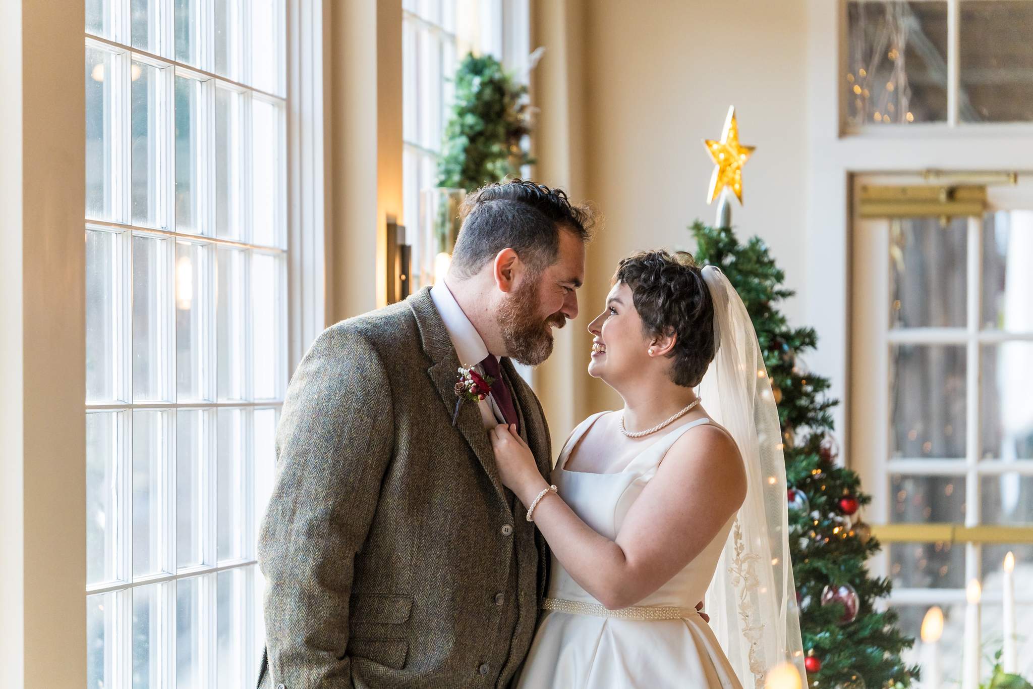 Couple sharing a quiet moment by the windows and a Christmas tree