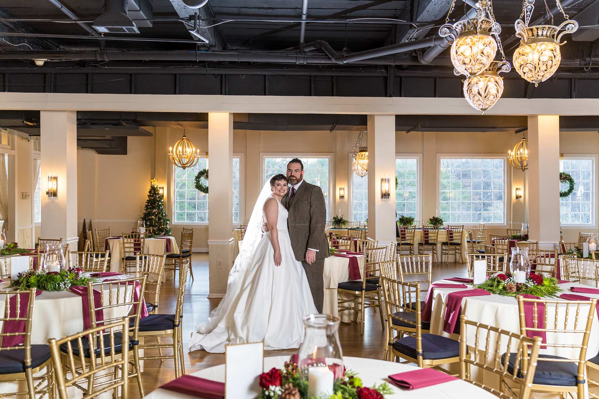 Couple standing in a reception room decorated for a Christmas wedding