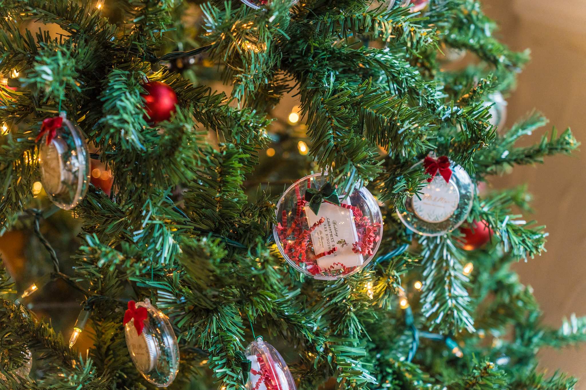 Close up of red and clear ornaments on a Christmas tree at a wedding