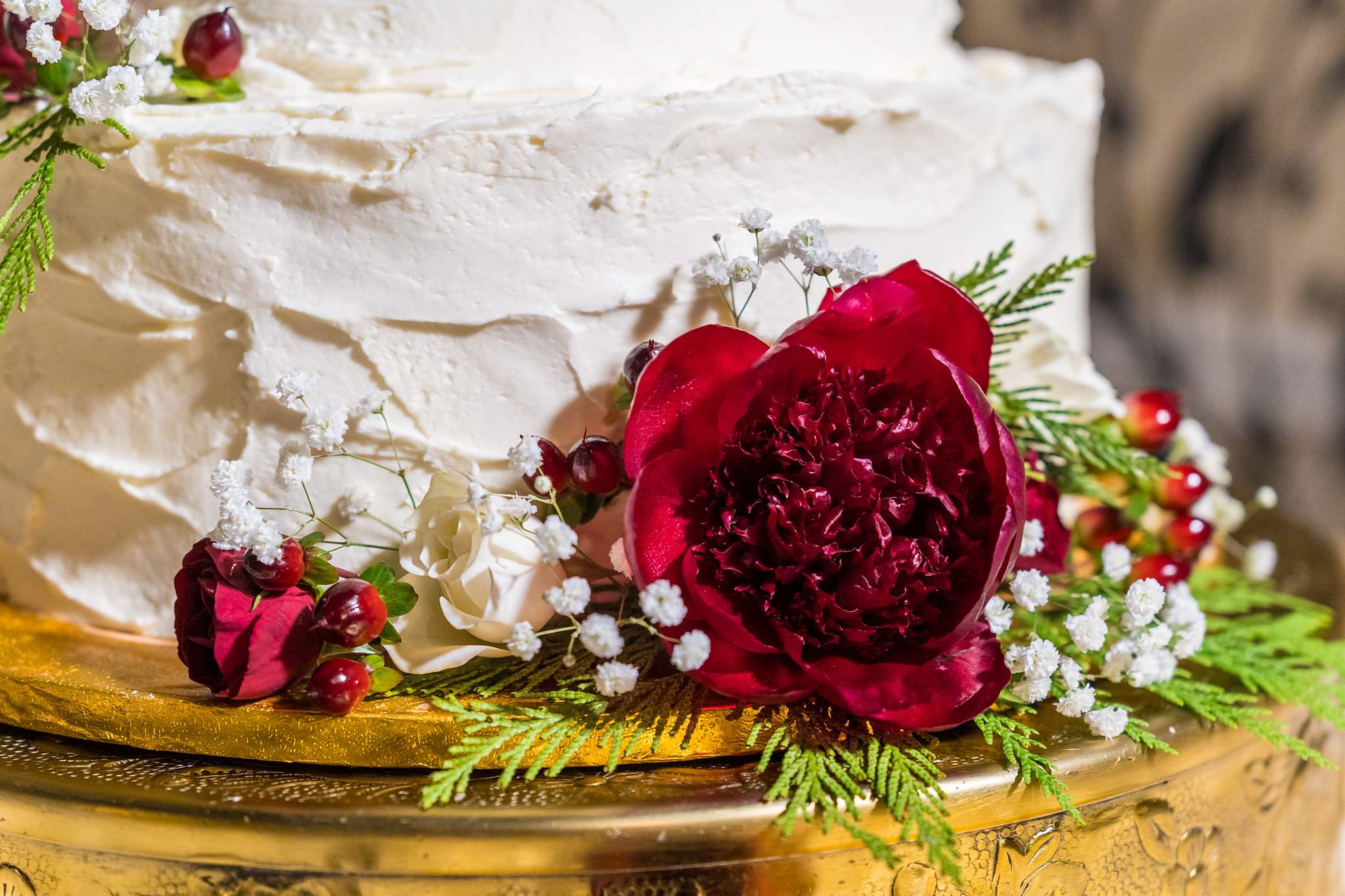 Detail of a red peony and berries on a Christmas wedding cake