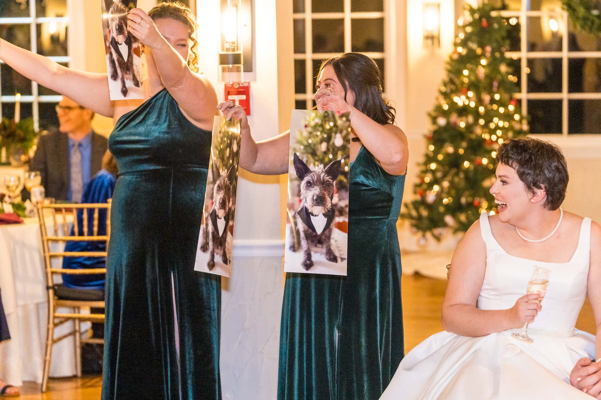 Bridesmaids holding up photos during a Christmas wedding toast
