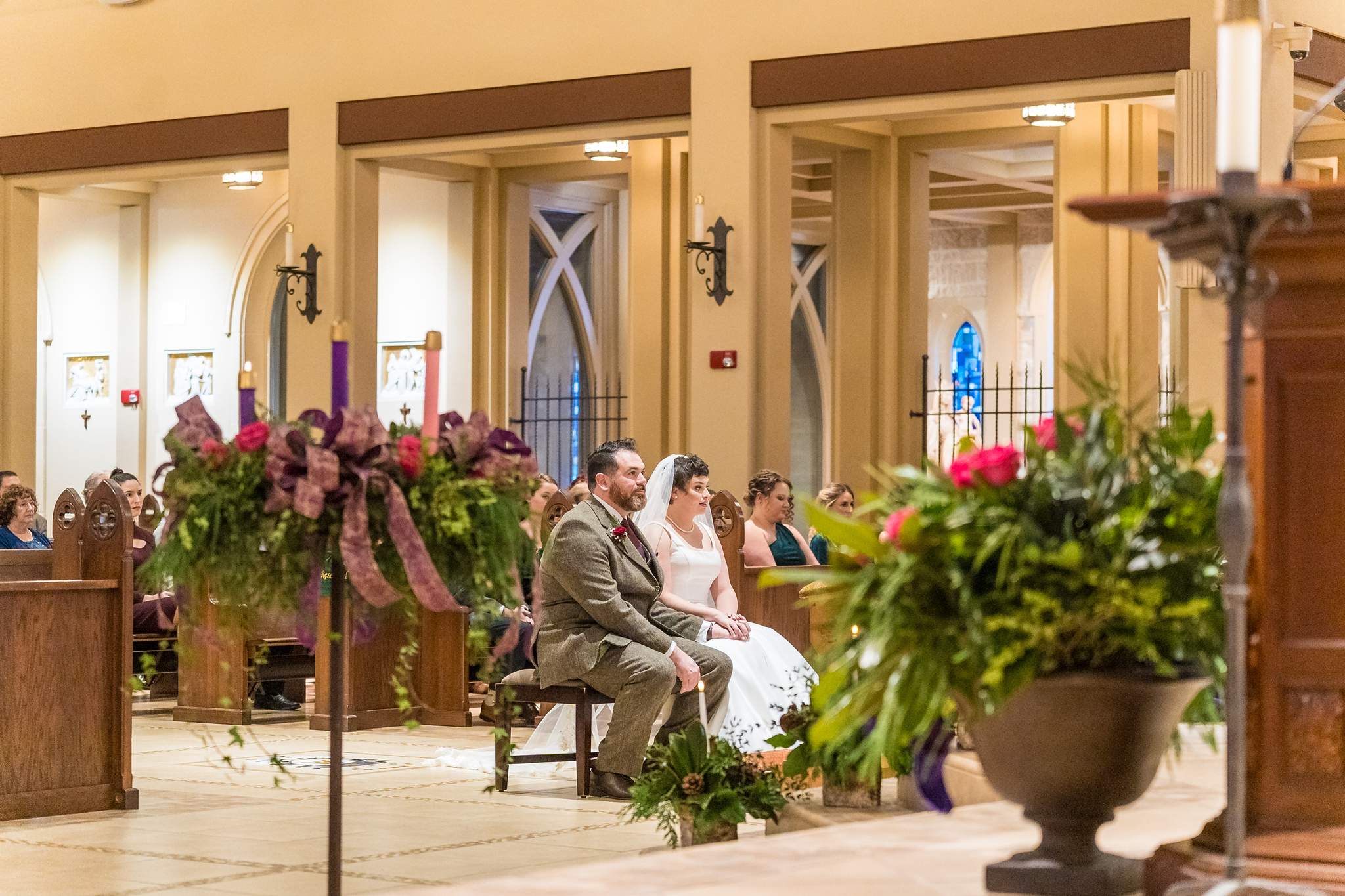 Church sanctuary decorated with greenery and wreaths for a December wedding