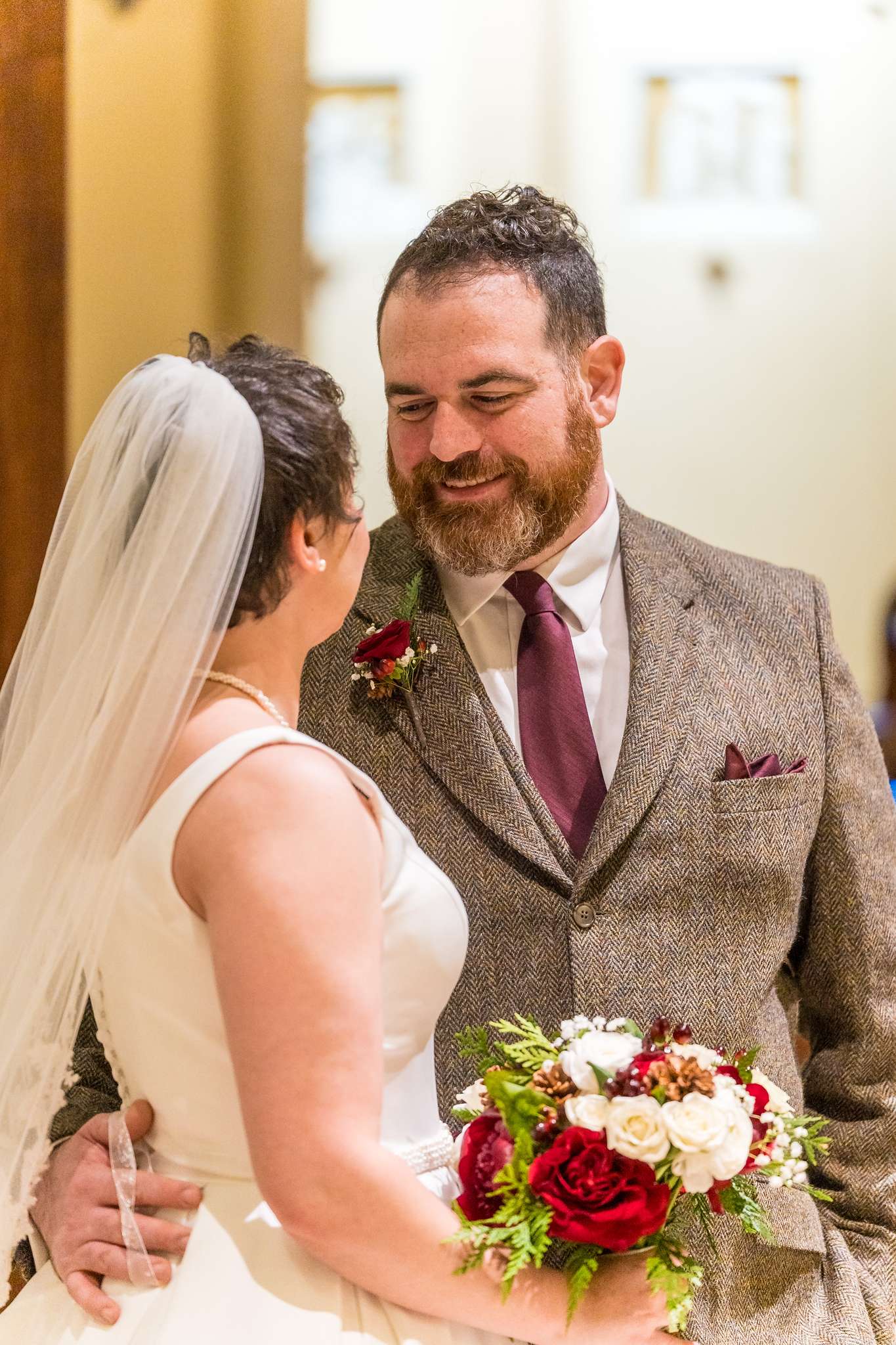 Couple smiling with a red and white winter bouquet