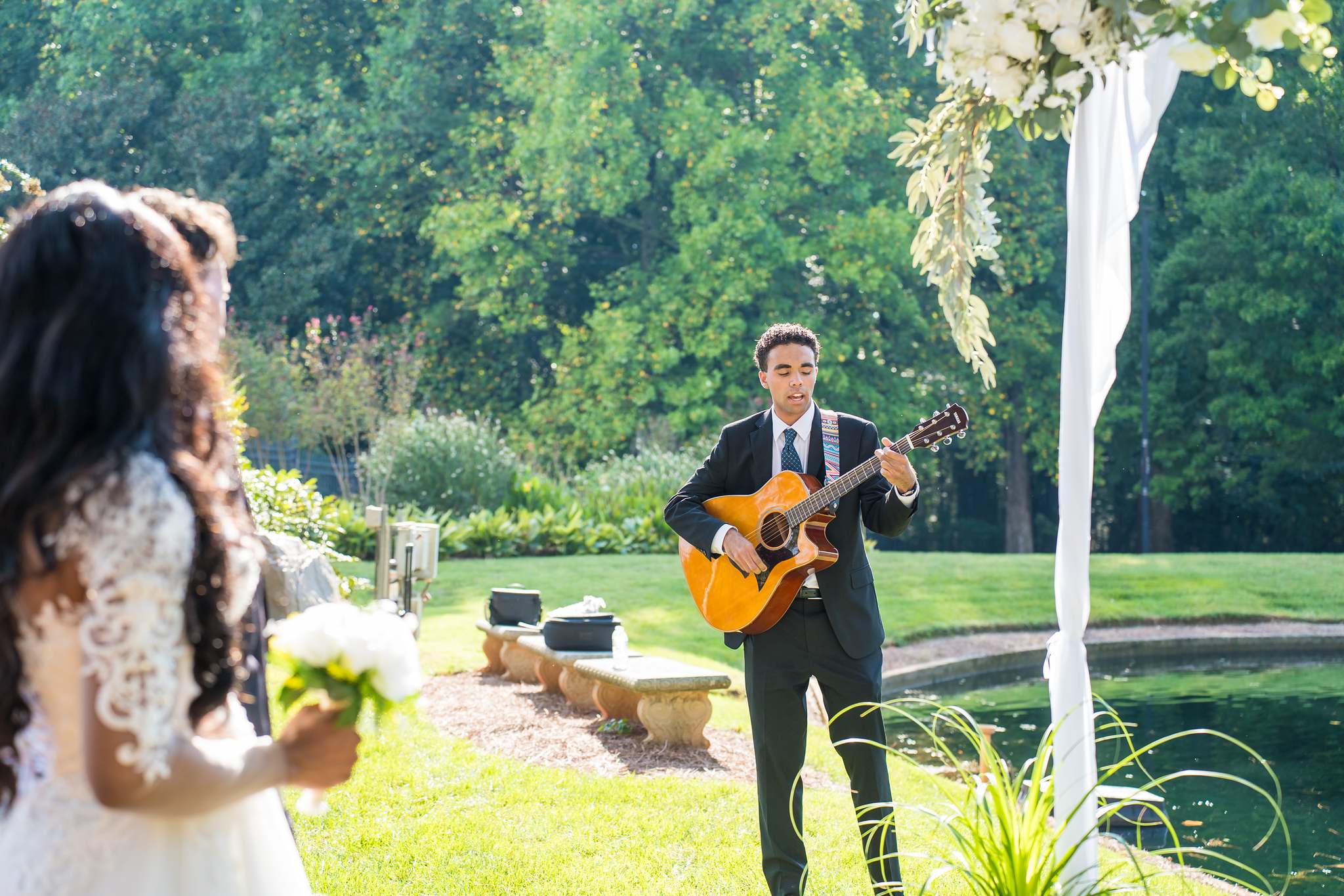 Bride smiling at the guitarist during an intimate outdoor elopement