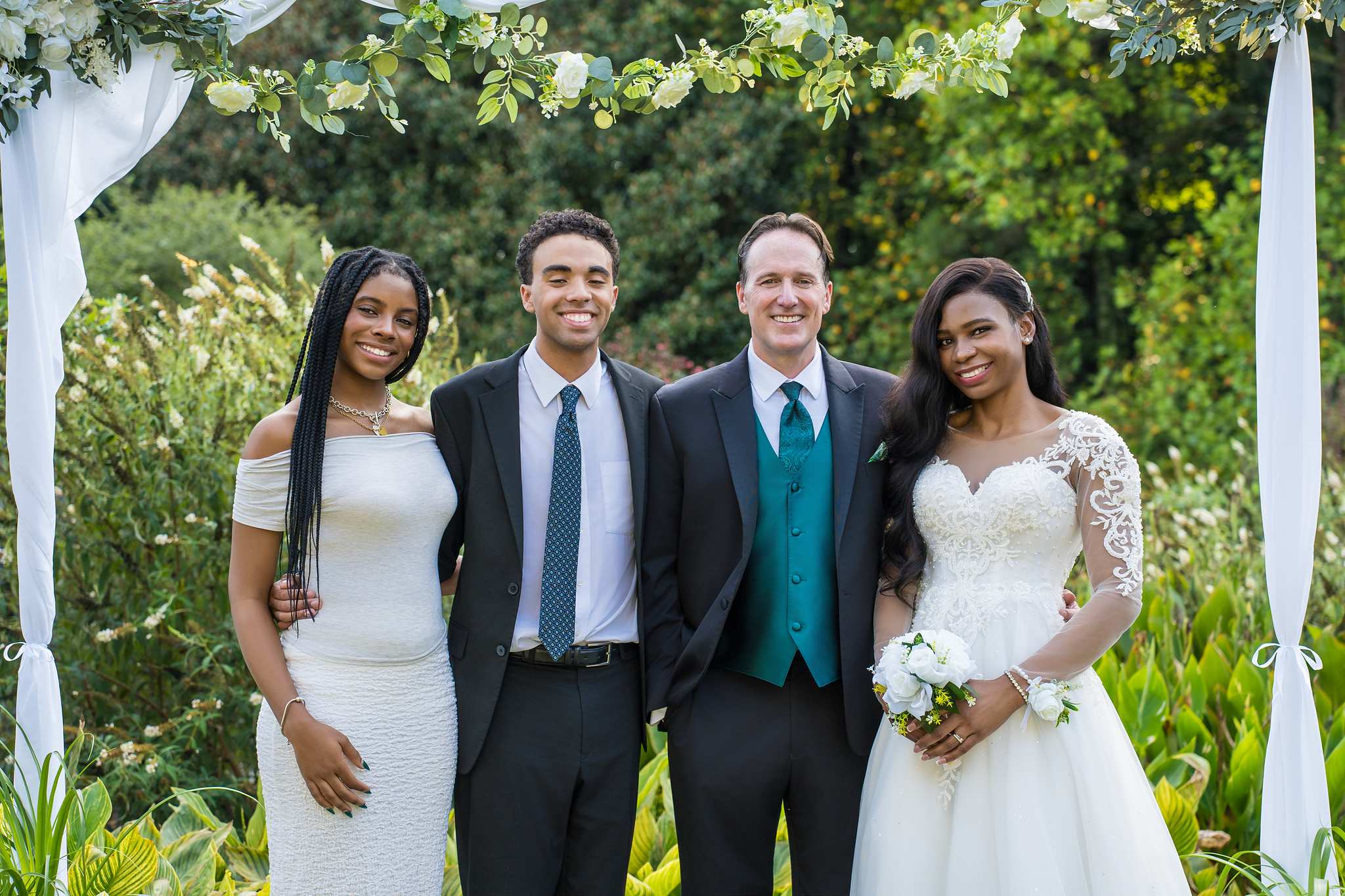 Newlyweds with friends in front of a floral arch after eloping in Atlanta