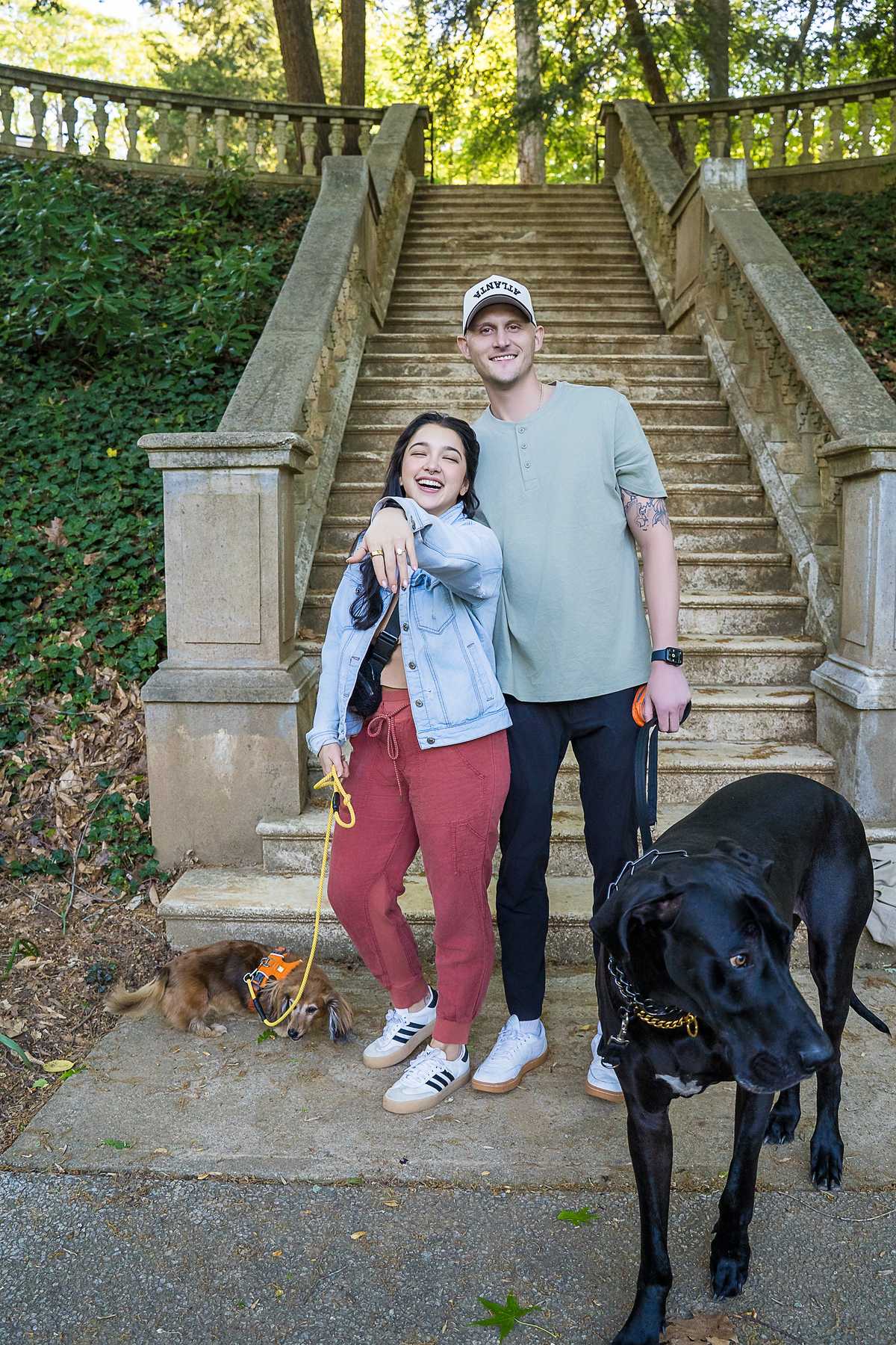 Couple posing at the foot of the stone staircase with their Great Dane and small dog at Cator Woolford Gardens