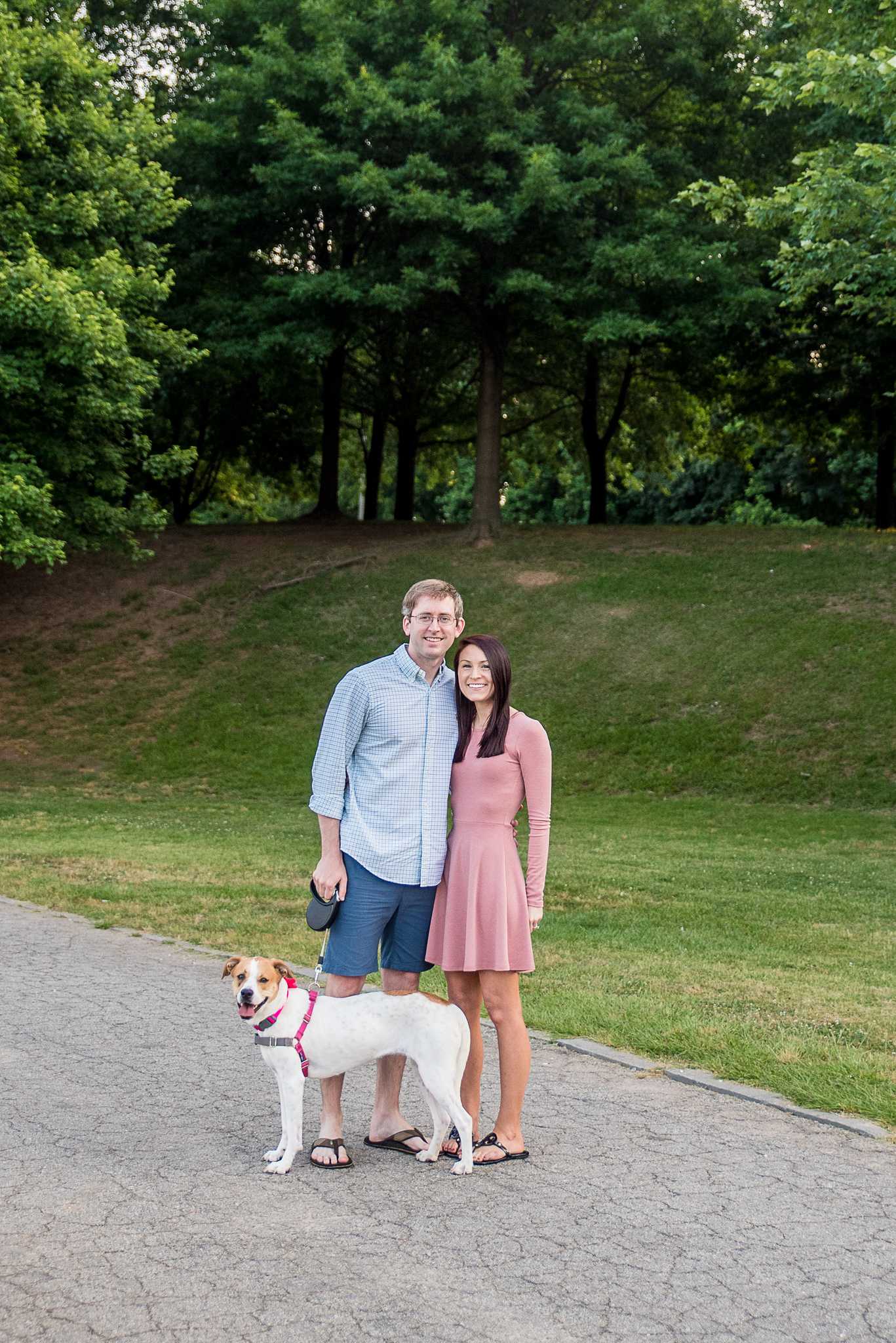 Couple standing on a park path at Piedmont Park with their leashed dog at their feet