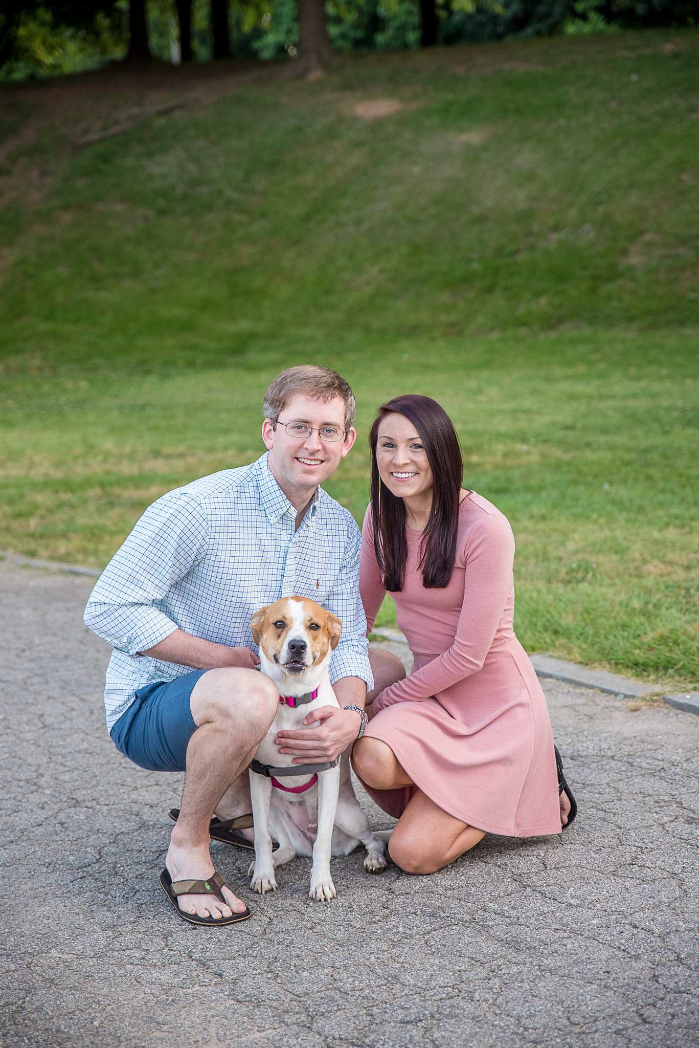 Couple kneeling close together with their dog in a pink collar at Piedmont Park