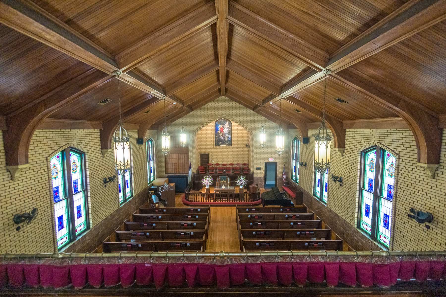 Sanctuary with a warm wood ceiling and stained glass at Fayetteville First United Methodist Church
