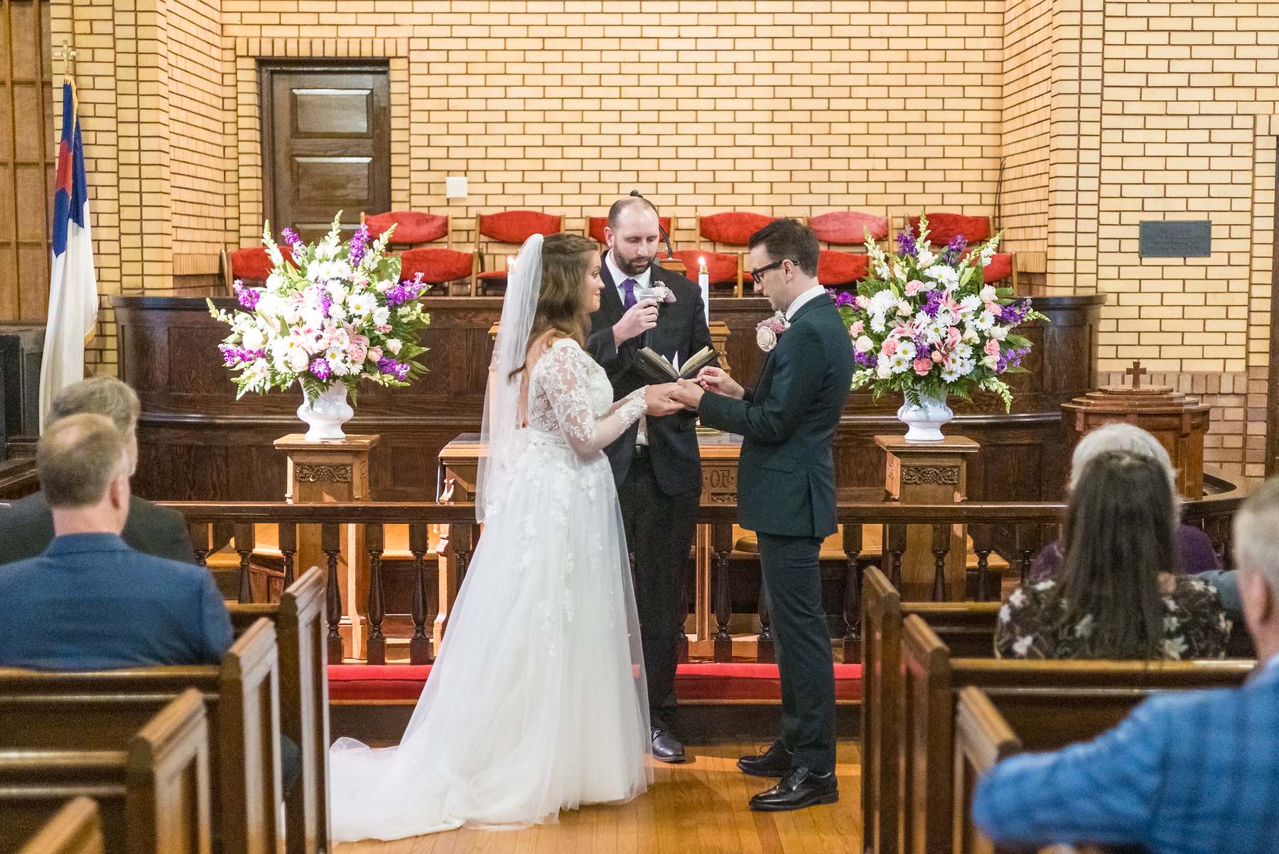Couple at the altar rail with flowers during their ceremony