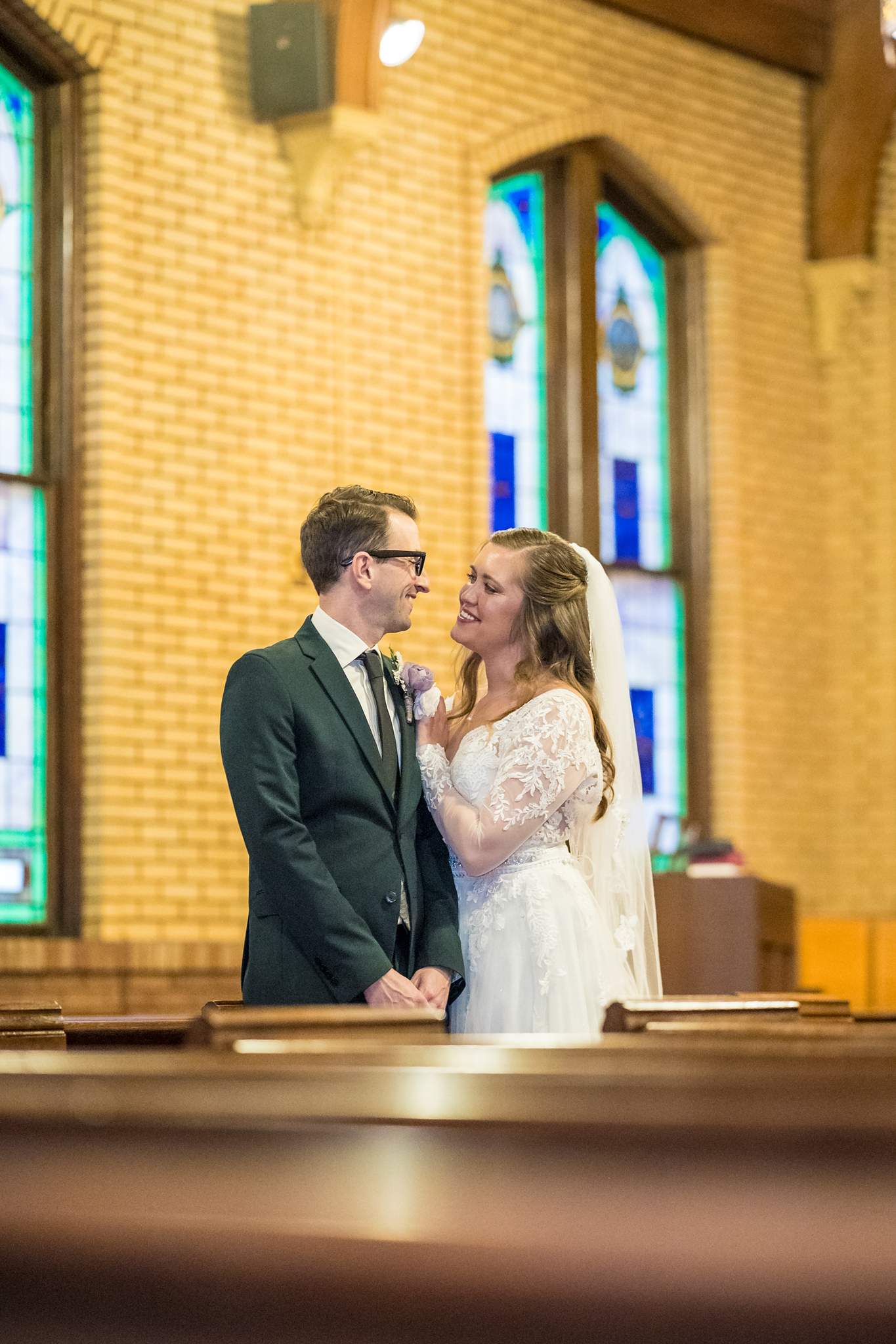 Couple portrait by a stained glass window at Fayetteville First United Methodist Church