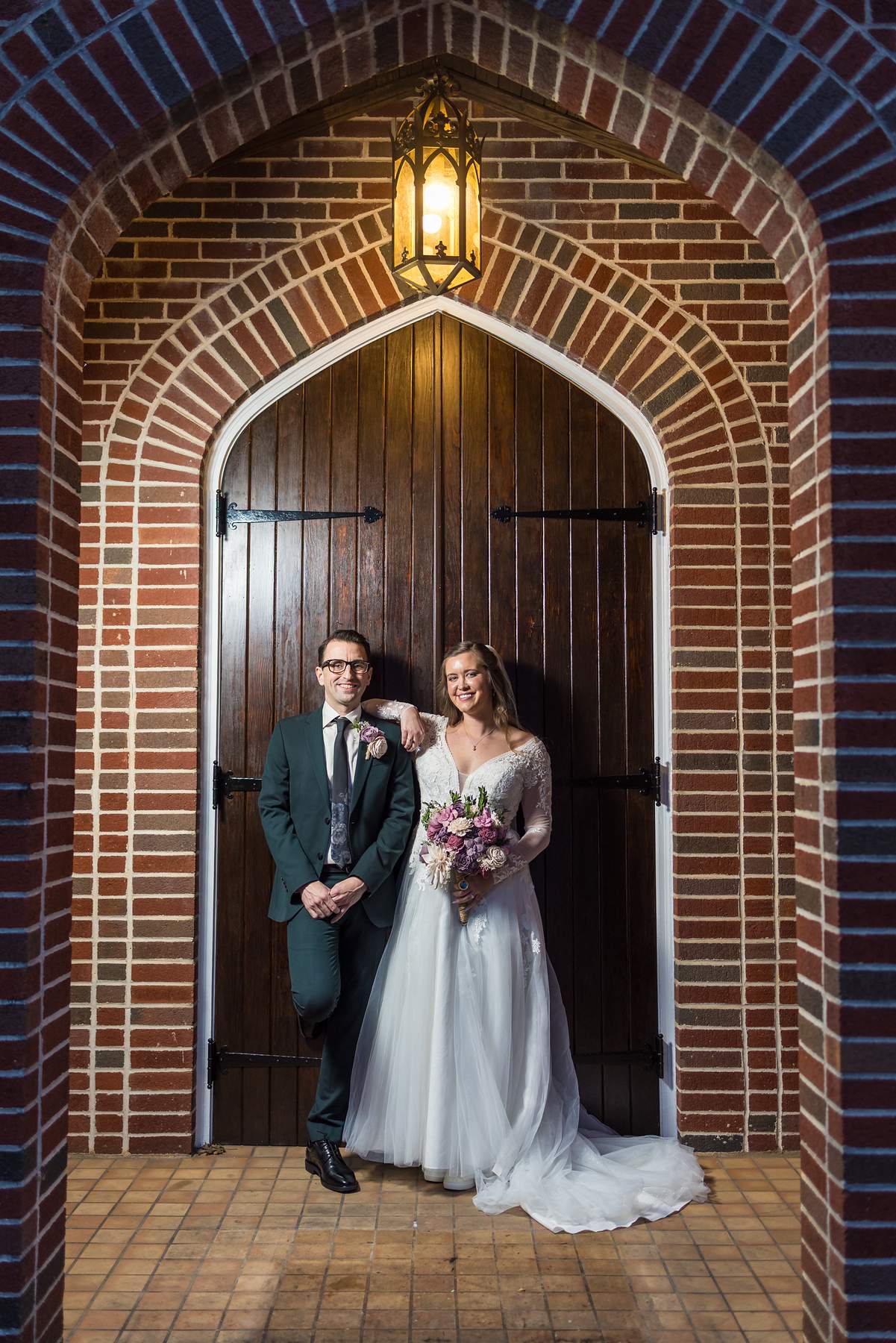 Couple in the arched brick doorway of Fayetteville First United Methodist Church