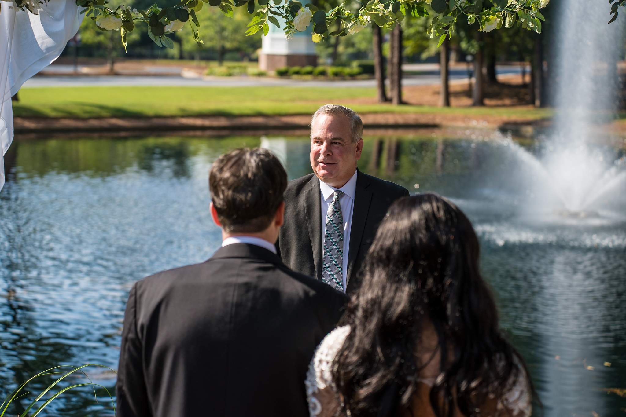 Officiant greeting the couple by the fountain on the grounds of First Baptist Atlanta
