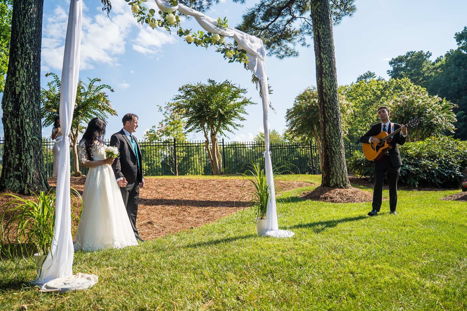 Outdoor ceremony under a draped arch on the grounds of First Baptist Atlanta